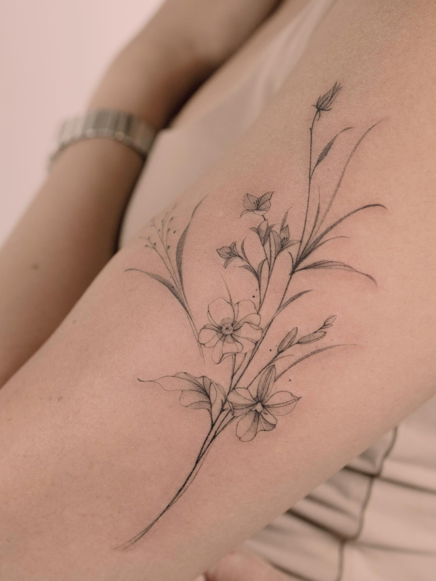 Floral arrangement black and grey tattoo on the forearm by Tattooist hea