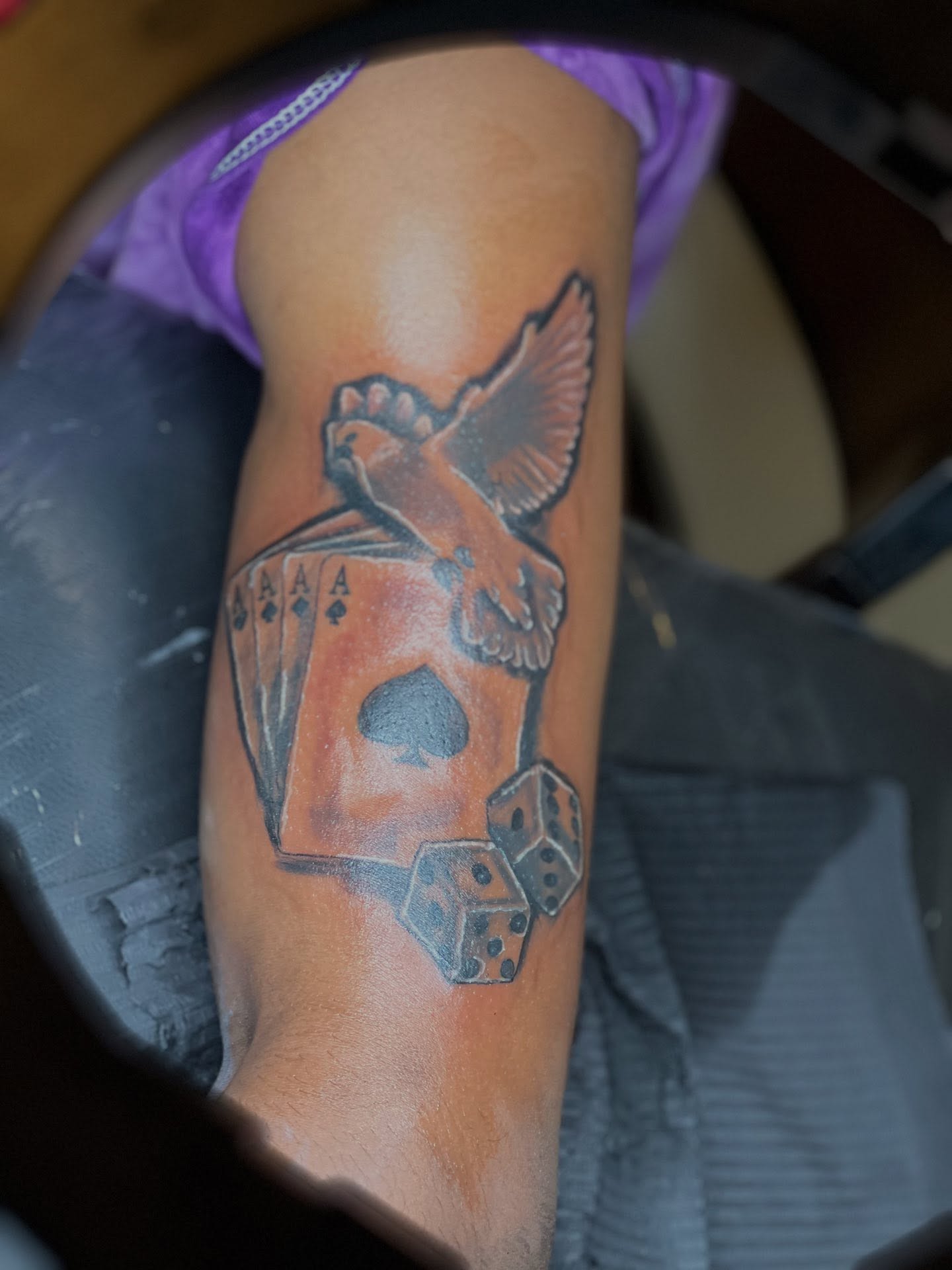 Playing cards and bird American traditional tattoo on the forearm by Illuminink.gallery