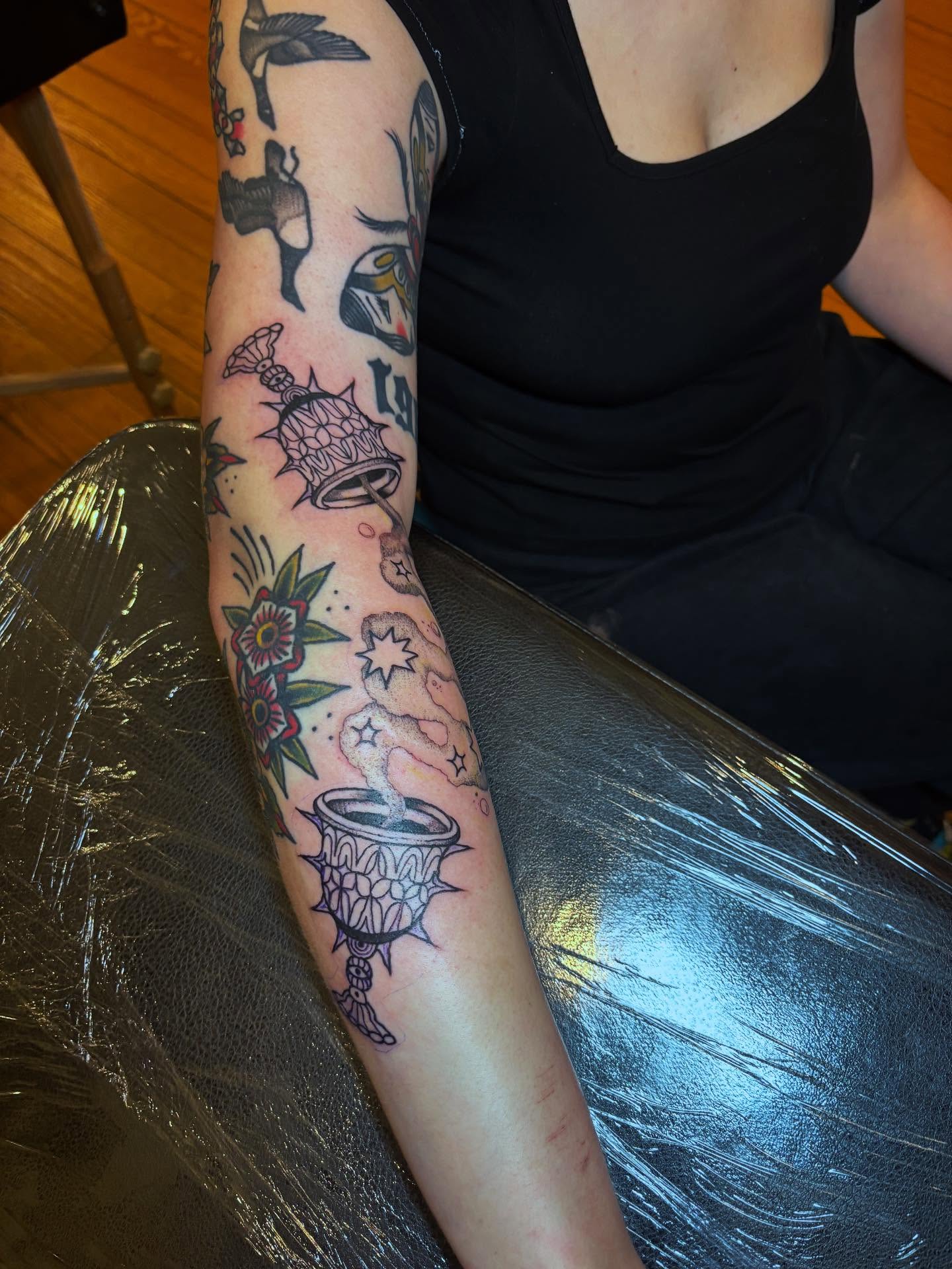 Bell and floral American traditional tattoo on the forearm by kris noble floyd