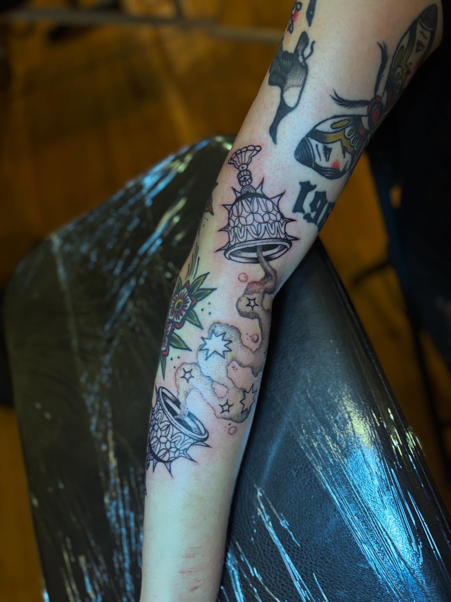 Bell and floral American traditional tattoo on the forearm by kris noble floyd