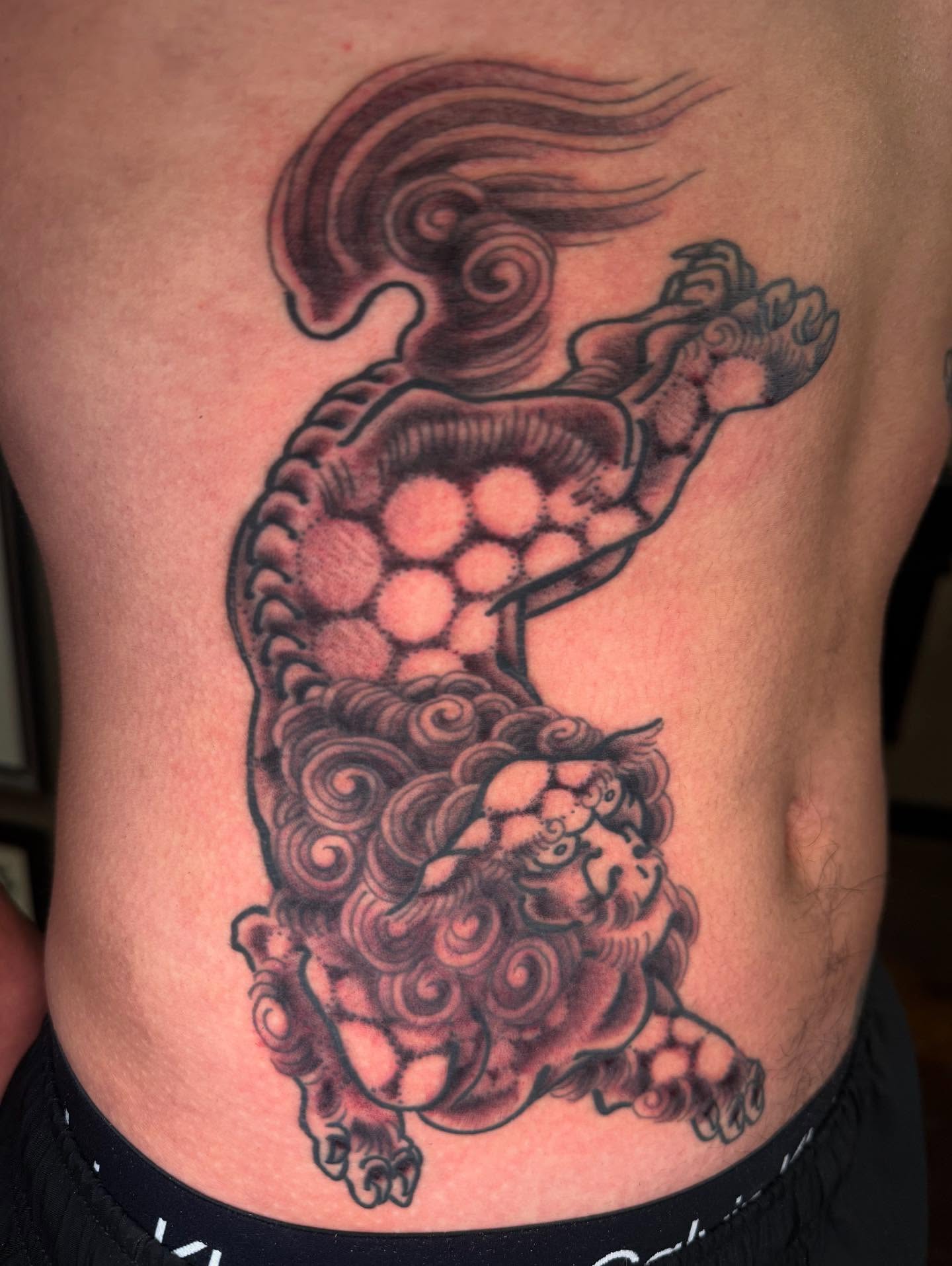 Lion and dragon black and grey tattoo on the ribs by Mike Diamond