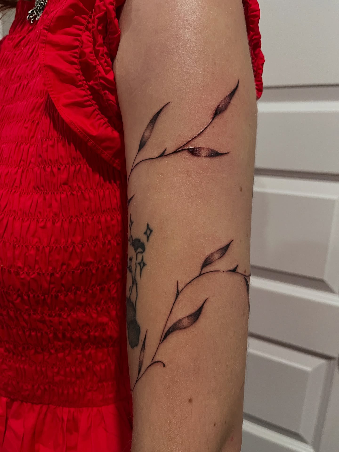 Branch with leaves black and grey tattoo on the forearm by layne