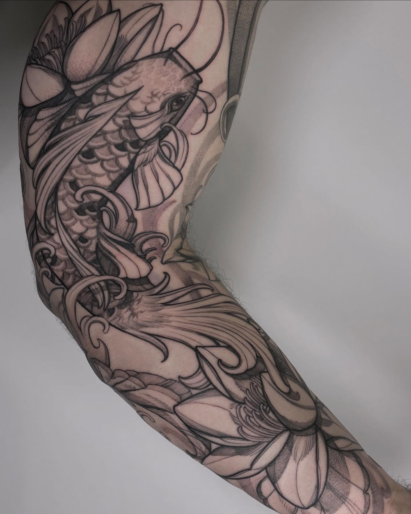 Koi fish black and grey tattoo on the forearm by Carol Jacky