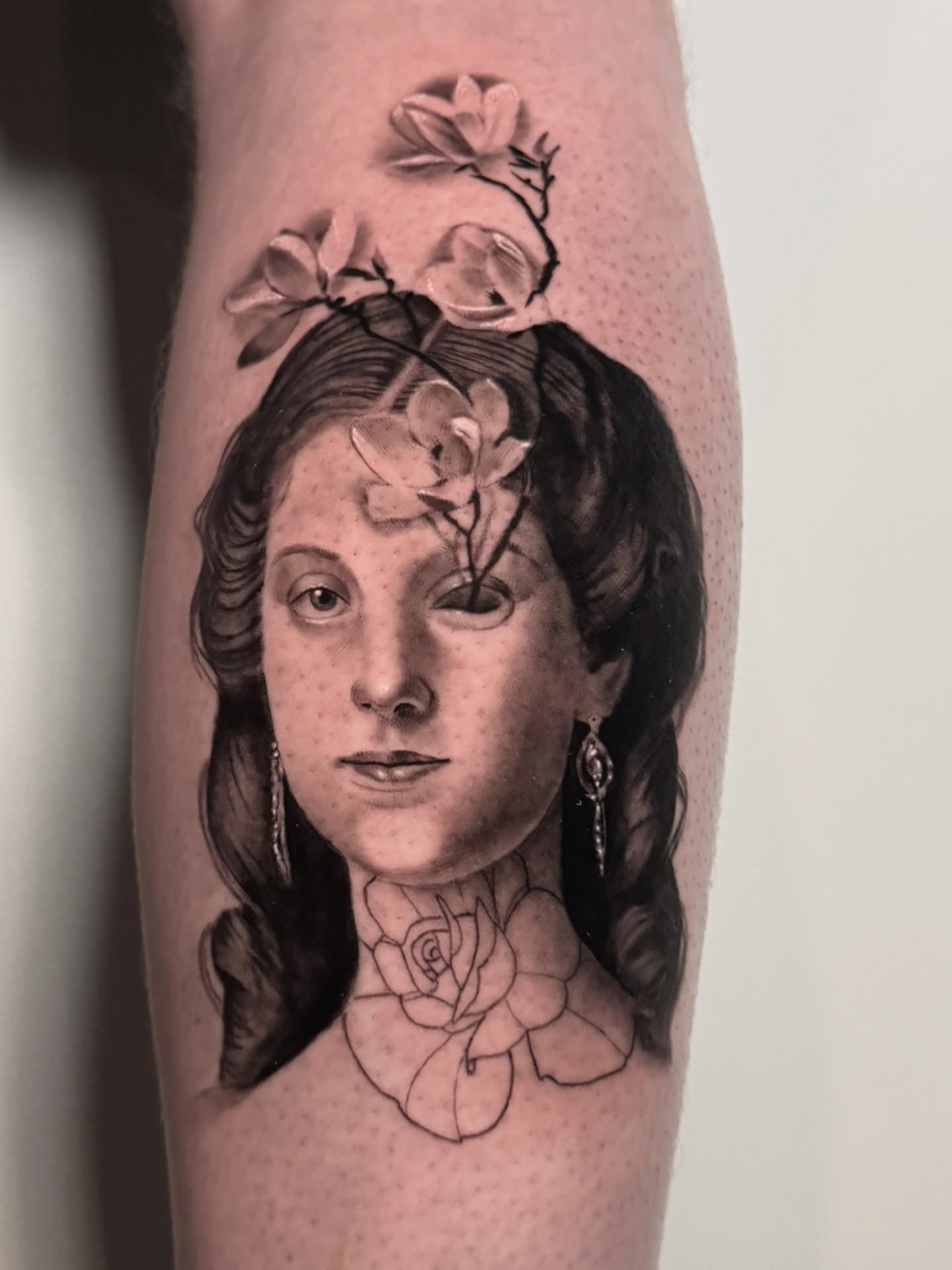 Woman with flowers realism tattoo on the forearm by Tori Bent