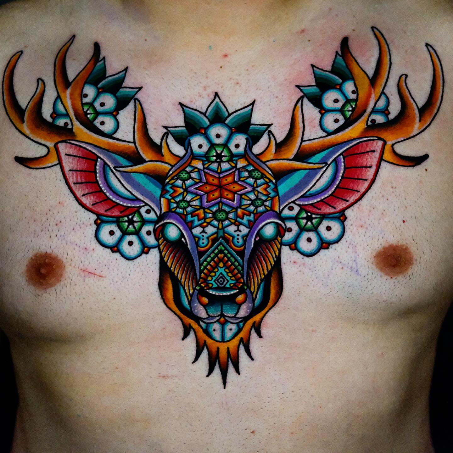 Deer skull geometric tattoo on the chest by Don Boos Tattoos