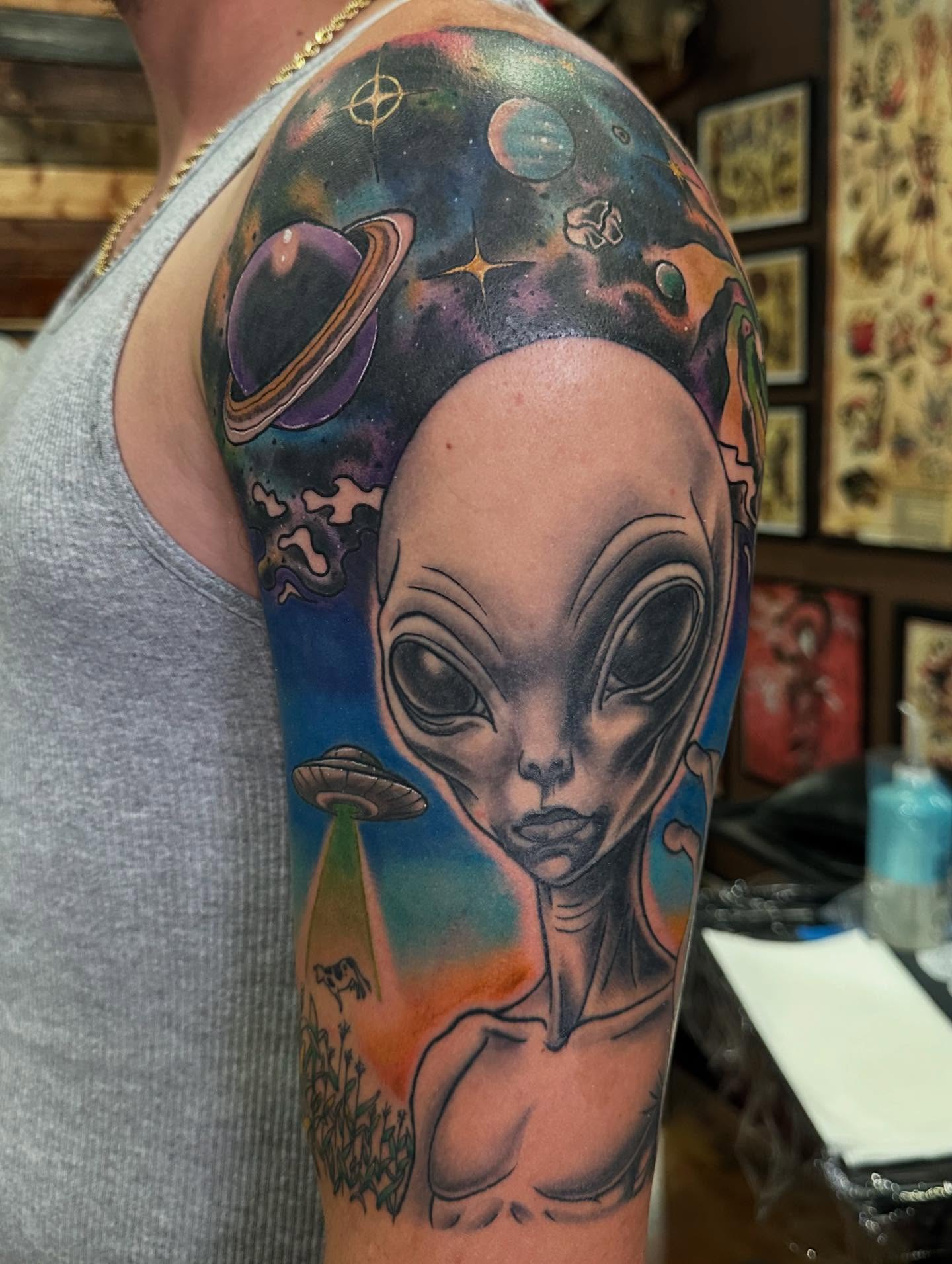 Alien and space scene surrealism tattoo on the forearm by Wesley Lam