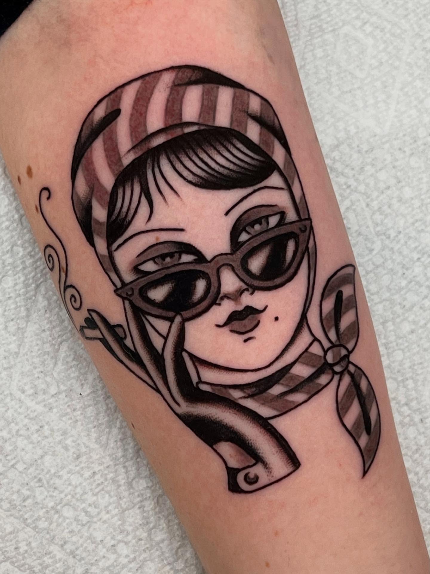 Woman wearing glasses American traditional tattoo on the forearm by Liv :)