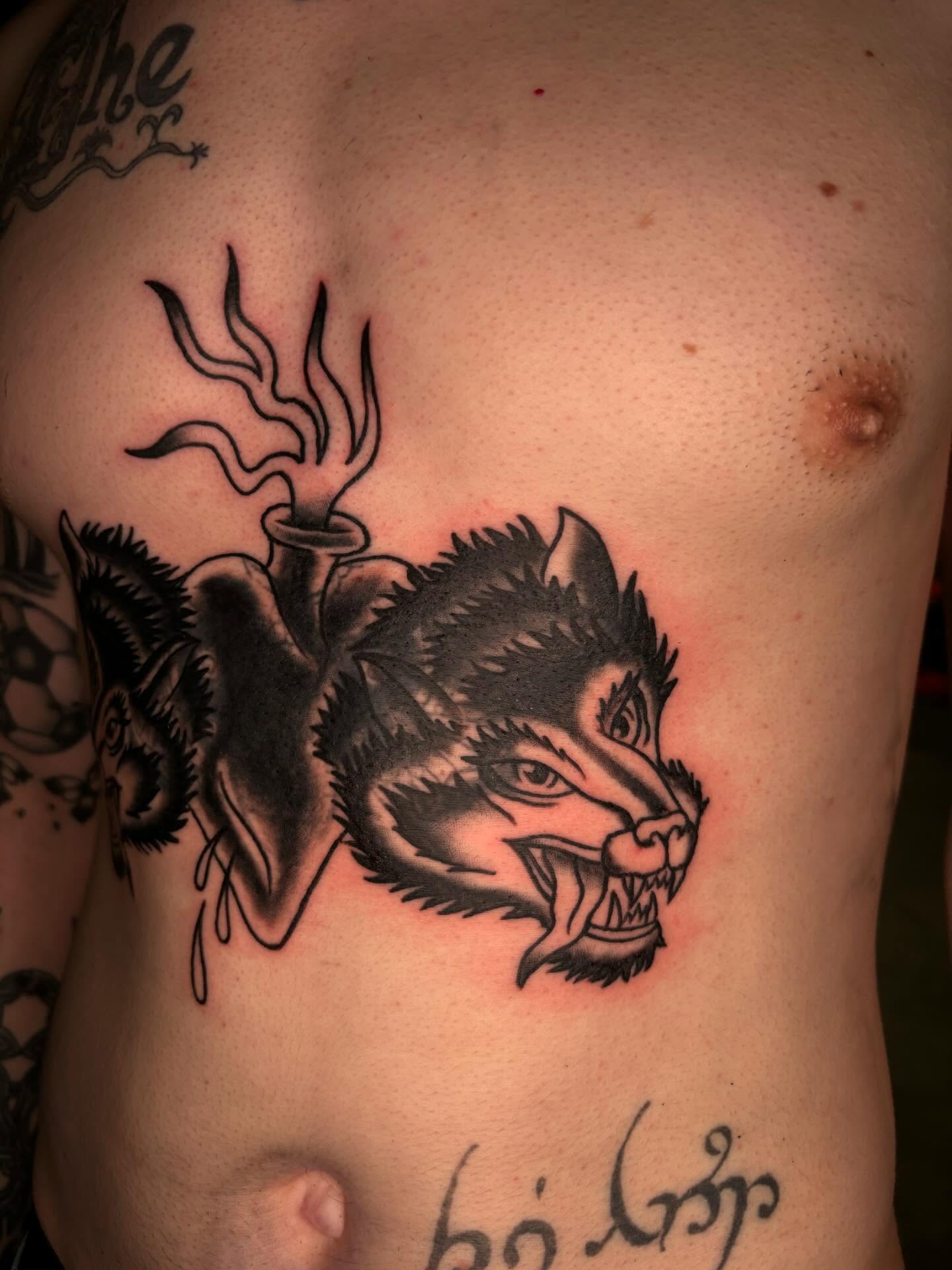Wolf American traditional tattoo on the chest by Brett Ferguson