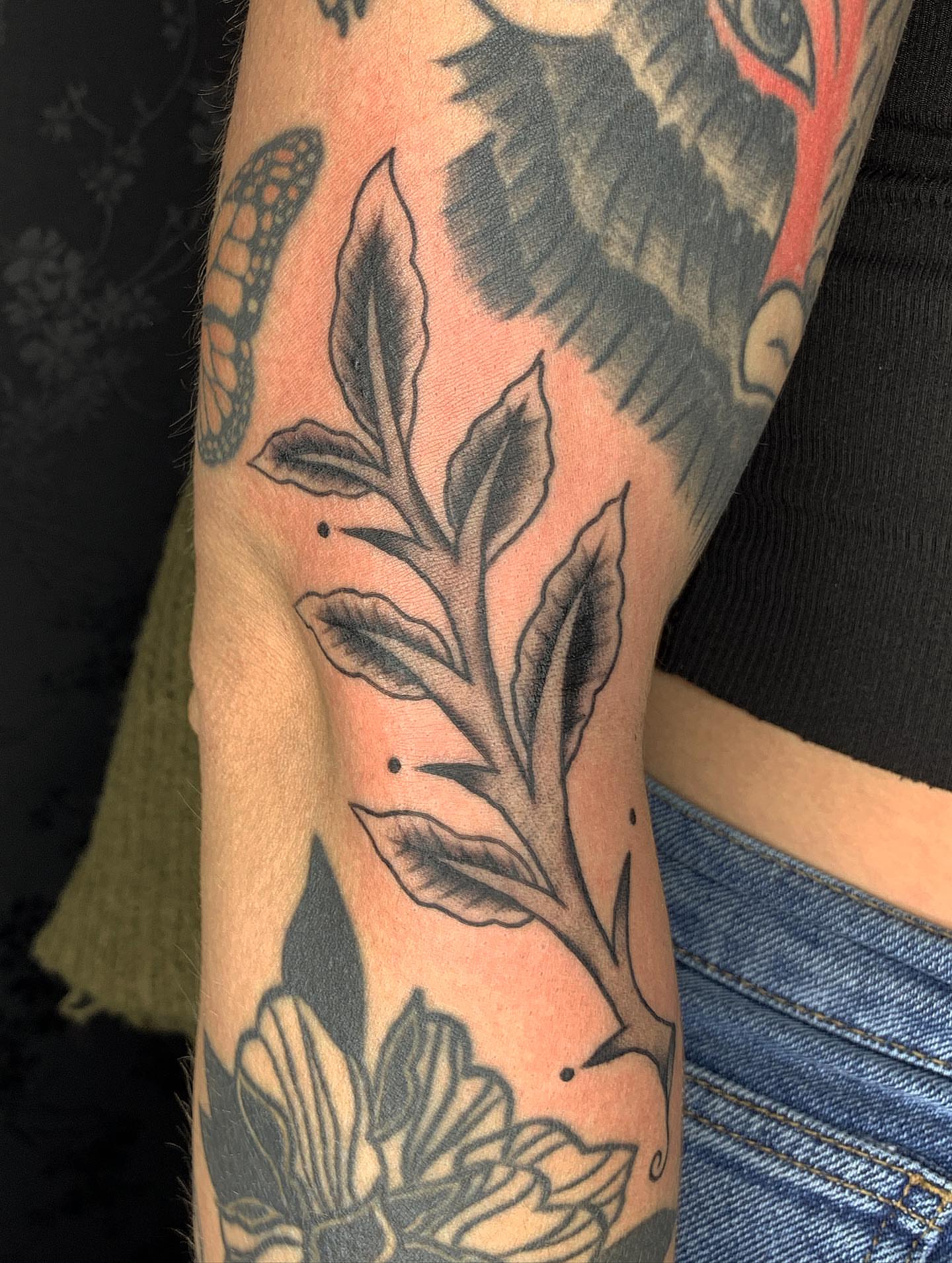 Branch with leaves black and grey tattoo on the forearm by Brii Moser