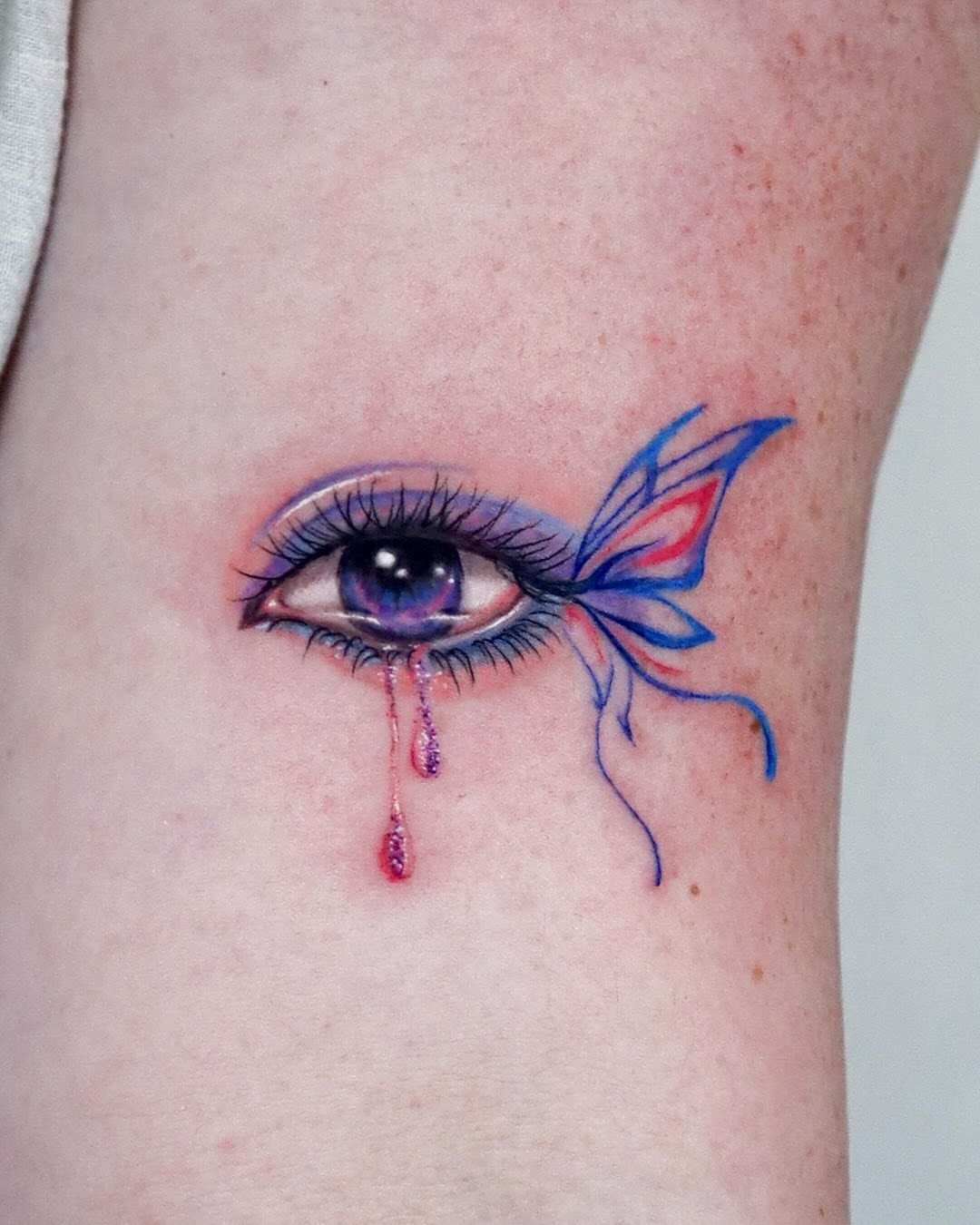 Eye with butterfly realism tattoo on the forearm by Mei