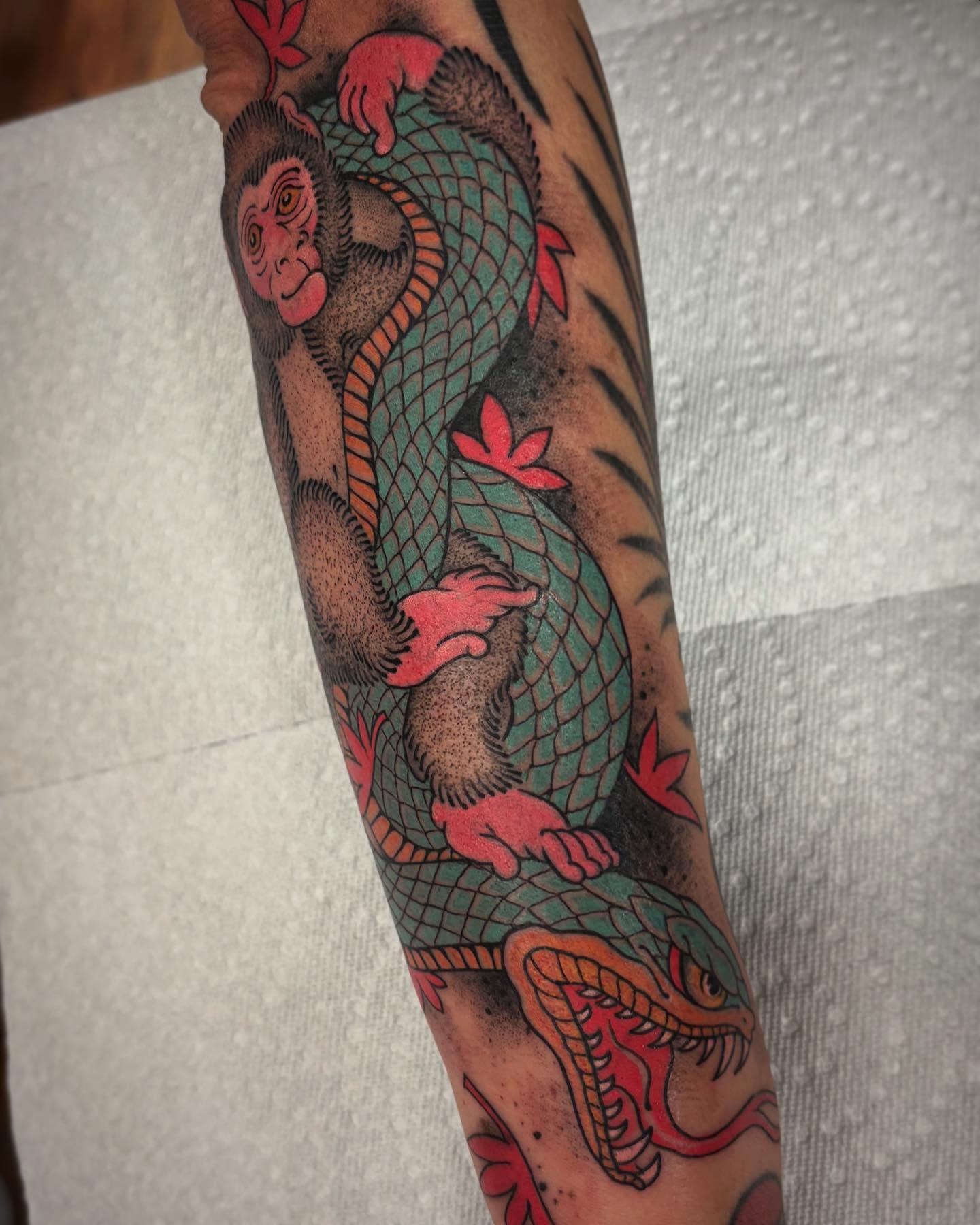 Monkey and dragon American traditional tattoo on the forearm by Pat Moser