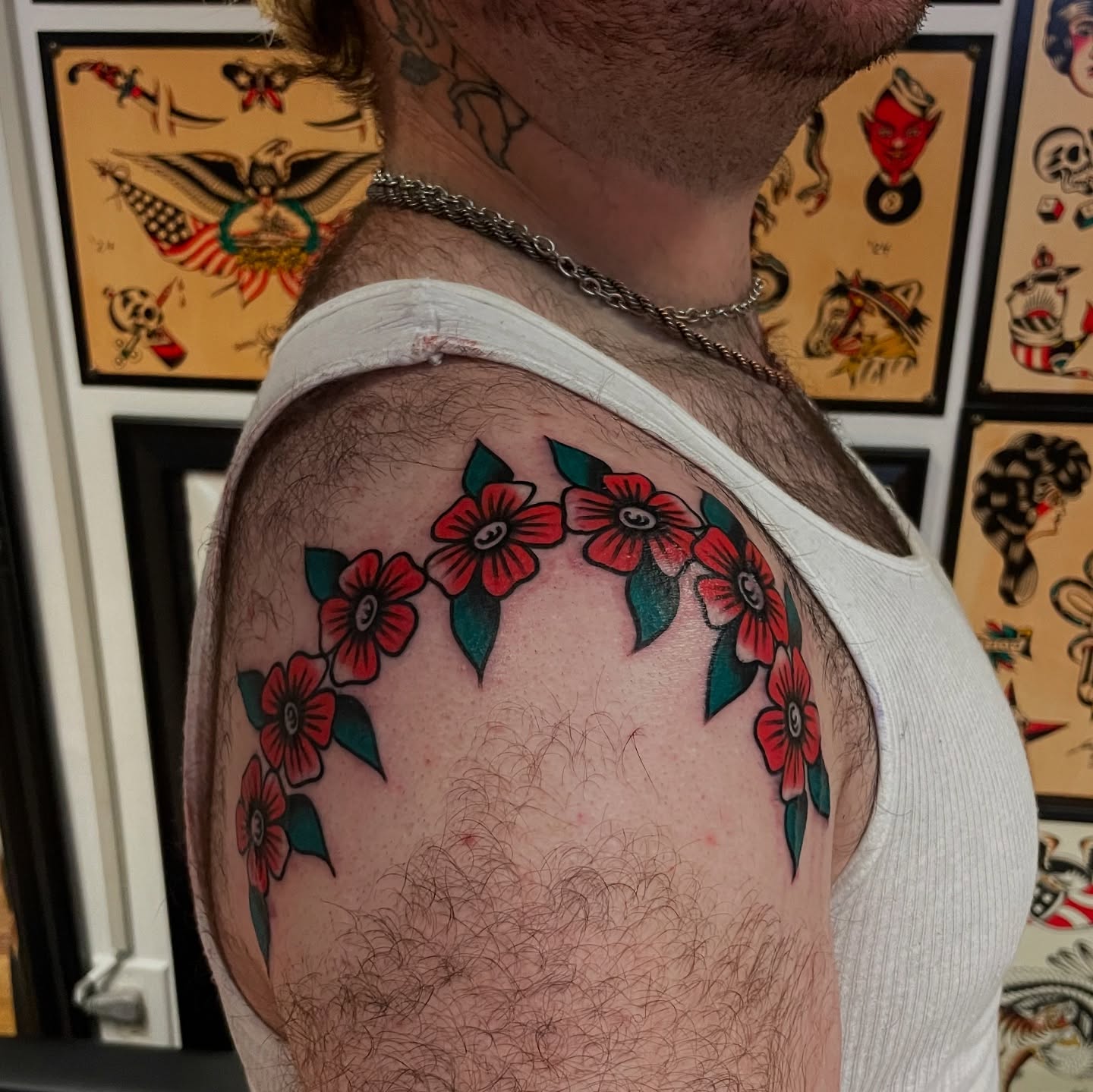 Flower chain American traditional tattoo on the shoulder by Texas Jonah