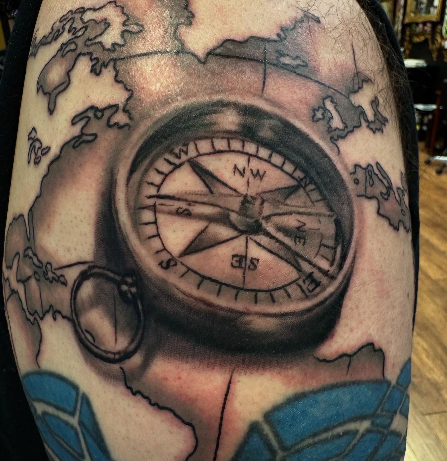 Compass black and grey tattoo on the upper arm by Kyle J. Bishop