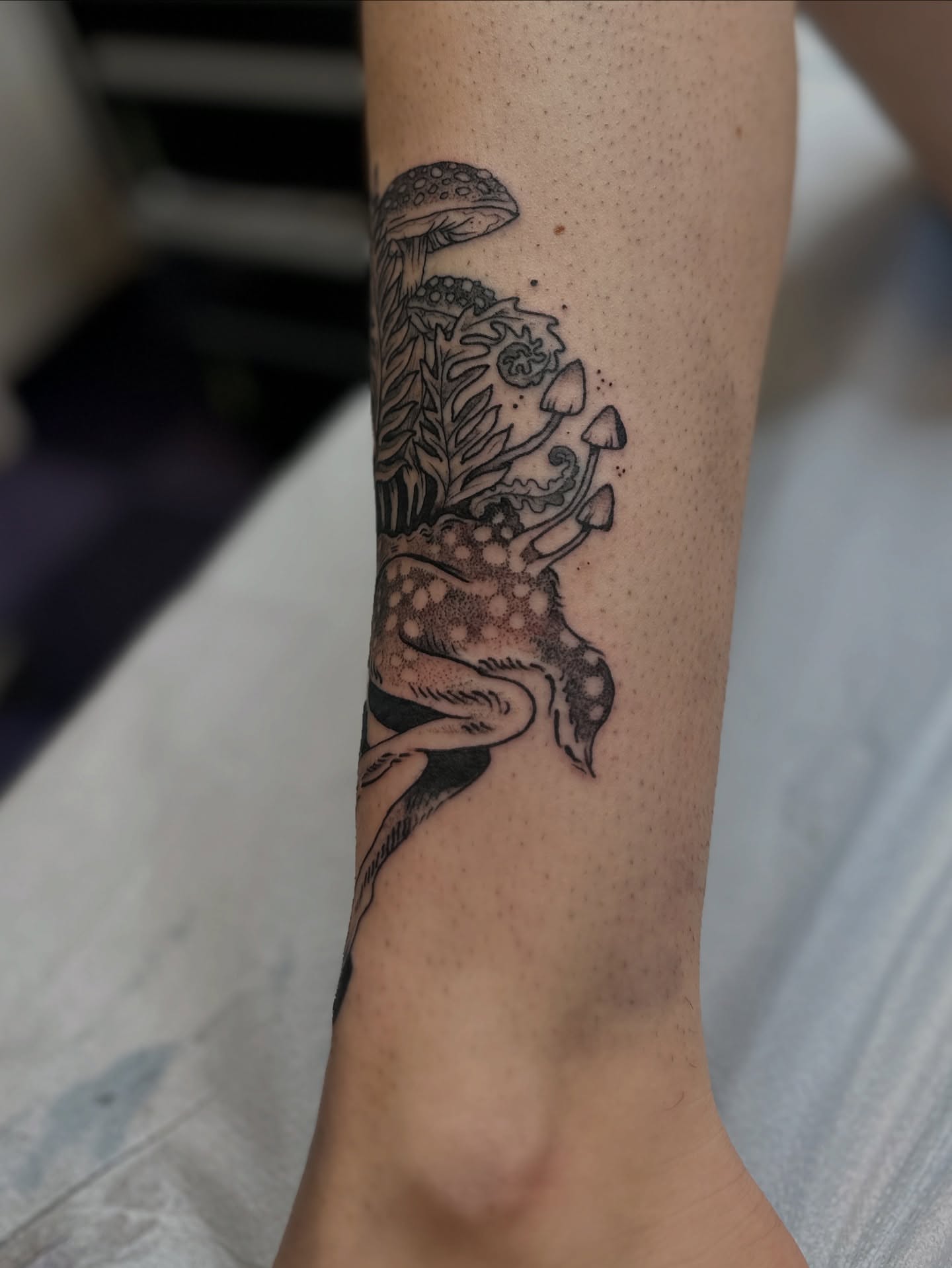 Mushroom and floral dotwork tattoo on the forearm by Emma Berger