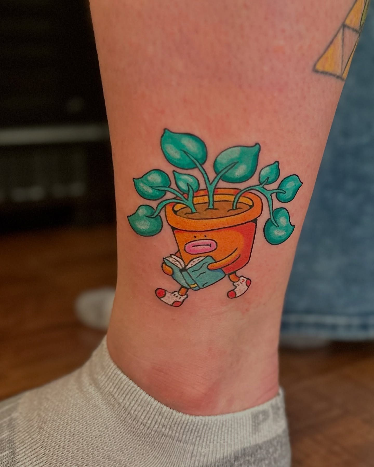 Plant pot character new school tattoo on the calf by Kellie Burch