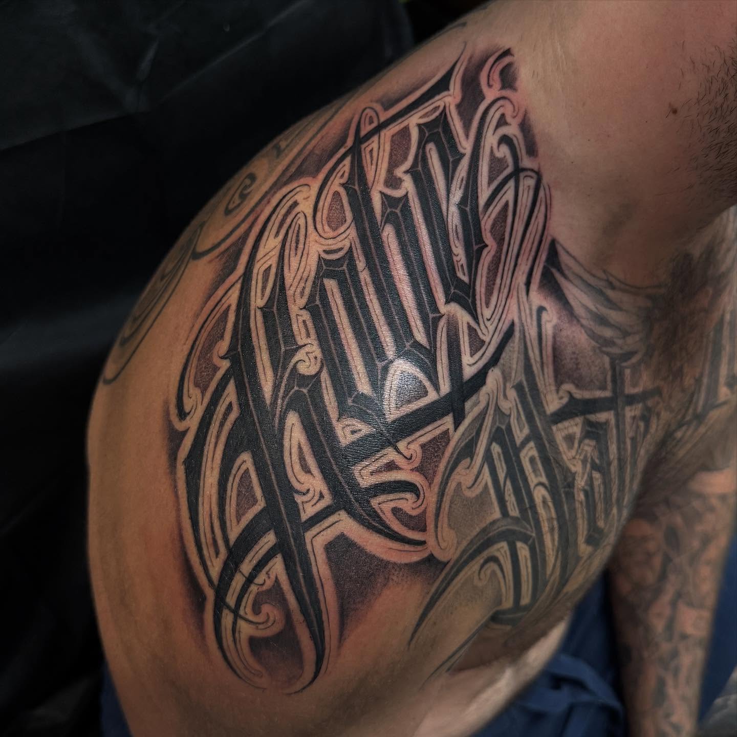 Gothic lettering lettering script tattoo on the shoulder by Chicanocustomlettering
