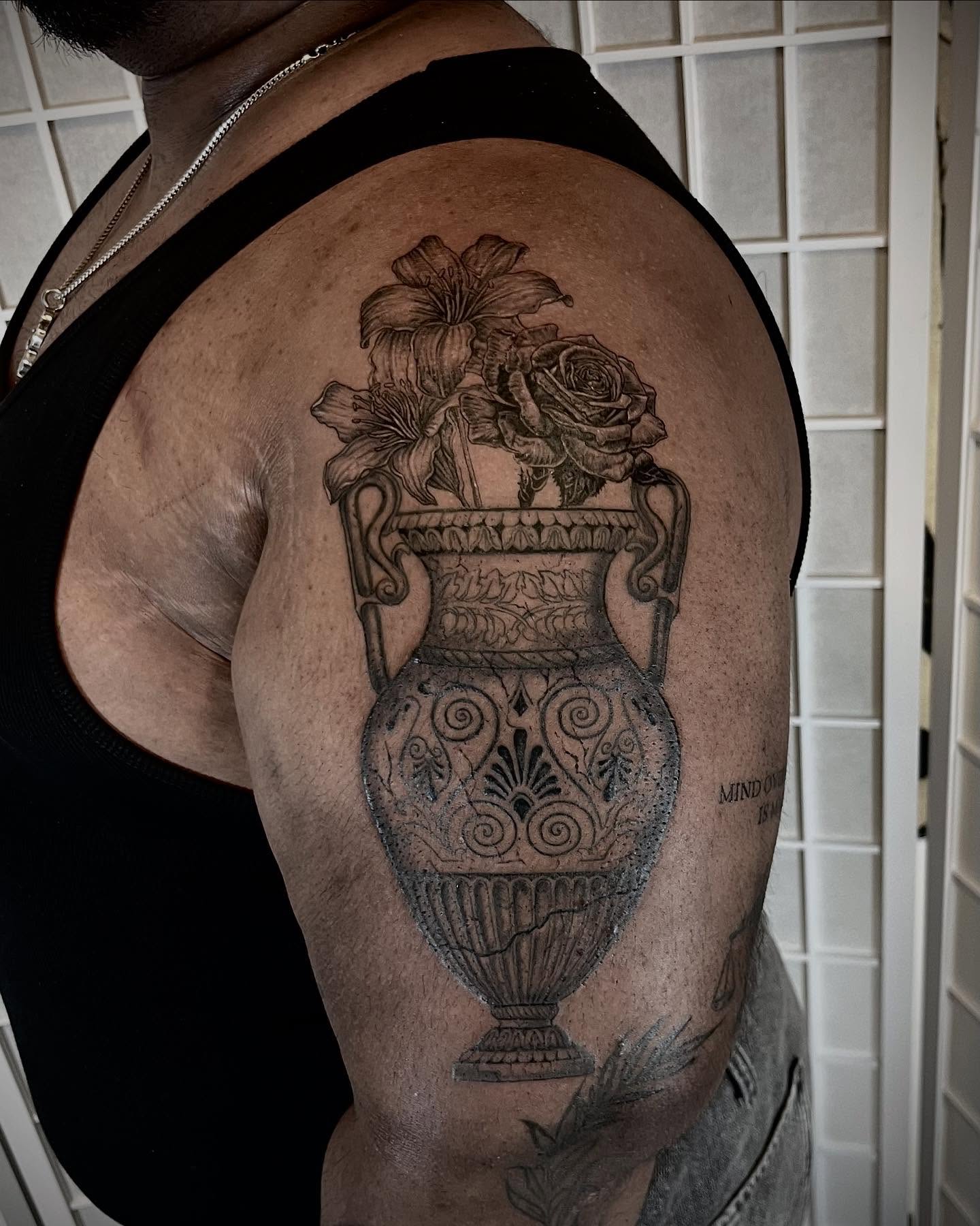 Vase with flowers realism tattoo on the shoulder by Tattoo Artist