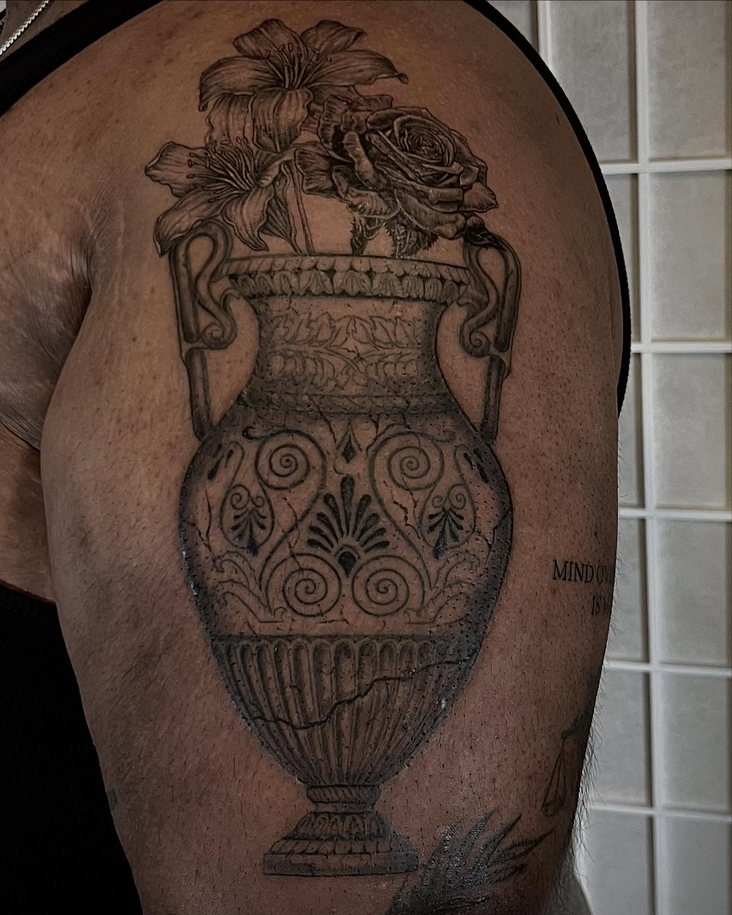 Vase with flowers realism tattoo on the shoulder by Tattoo Artist