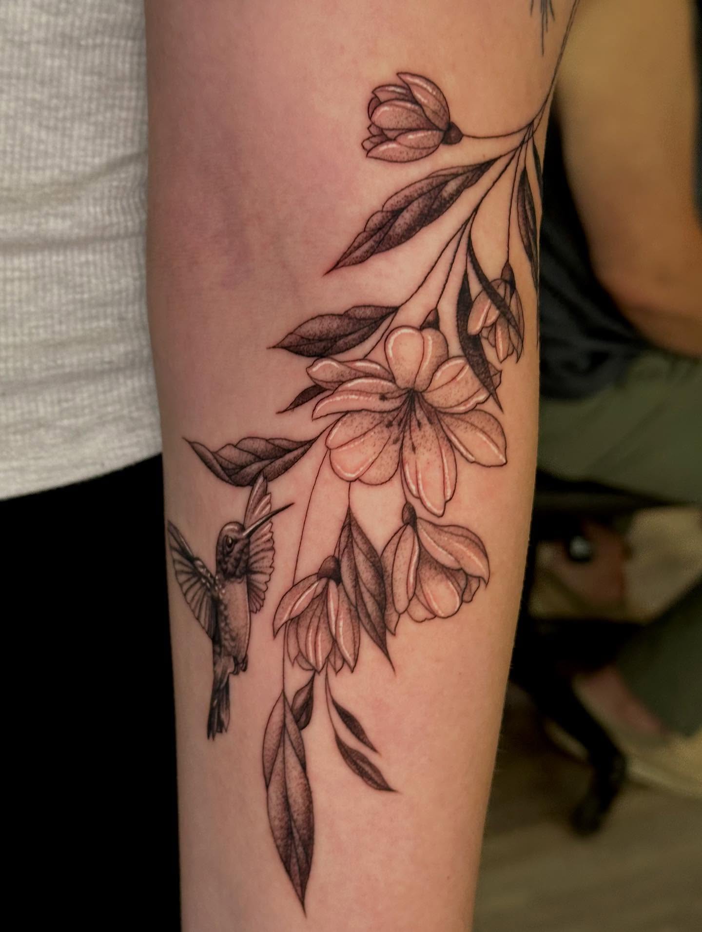 Hummingbird and flowers black and grey tattoo on the forearm by MR