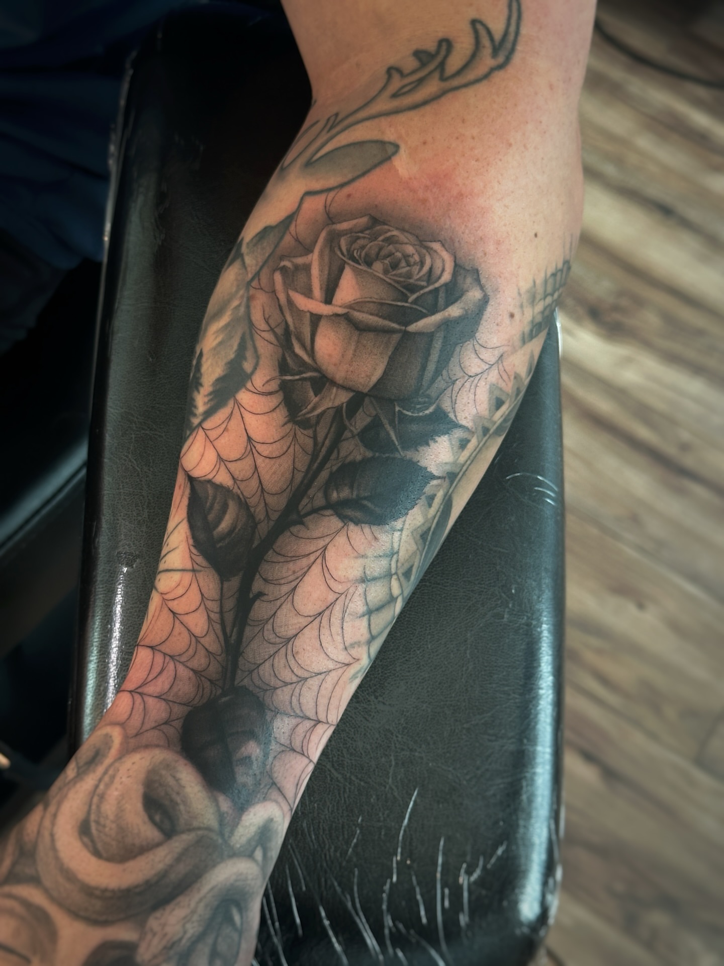 Rose and spiderweb realism tattoo on the forearm by Paige Jean