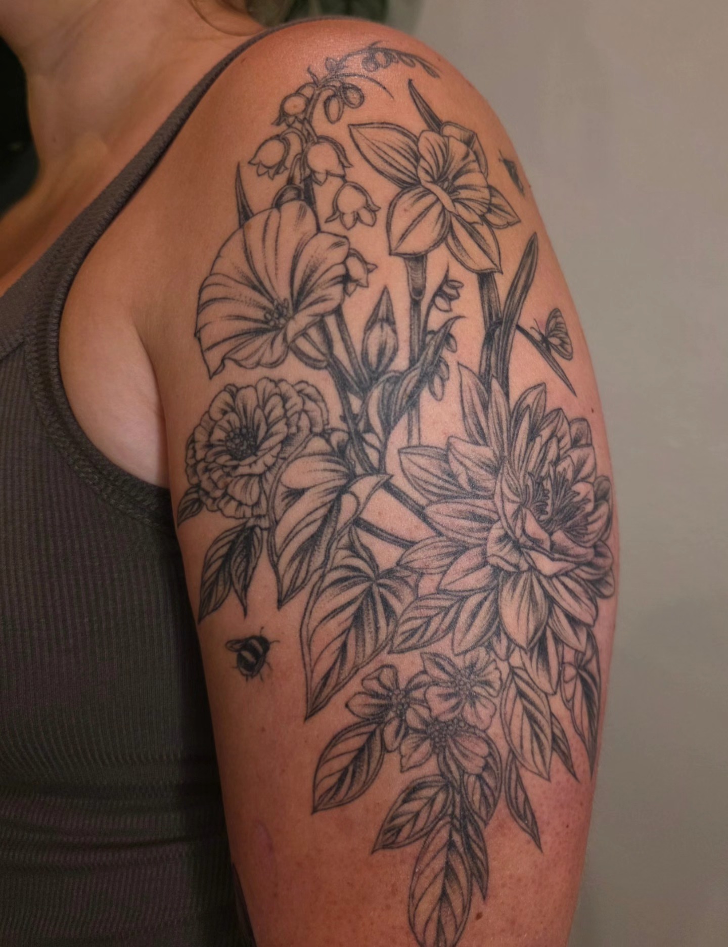 Floral bouquet realism tattoo on the shoulder by Sierra (cc) Klein