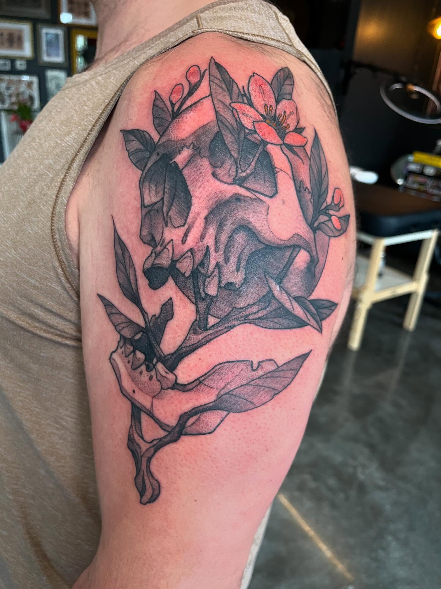 Skull with flowers realism tattoo on the shoulder by Ian White