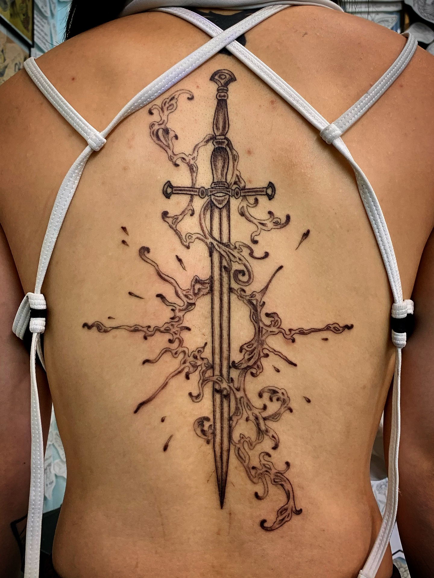 Sword black and grey tattoo on the back by Laura