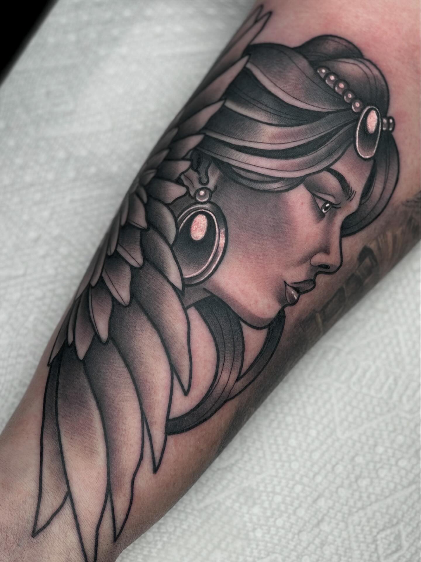 Woman with wings American traditional tattoo on the forearm by Katie Kelley