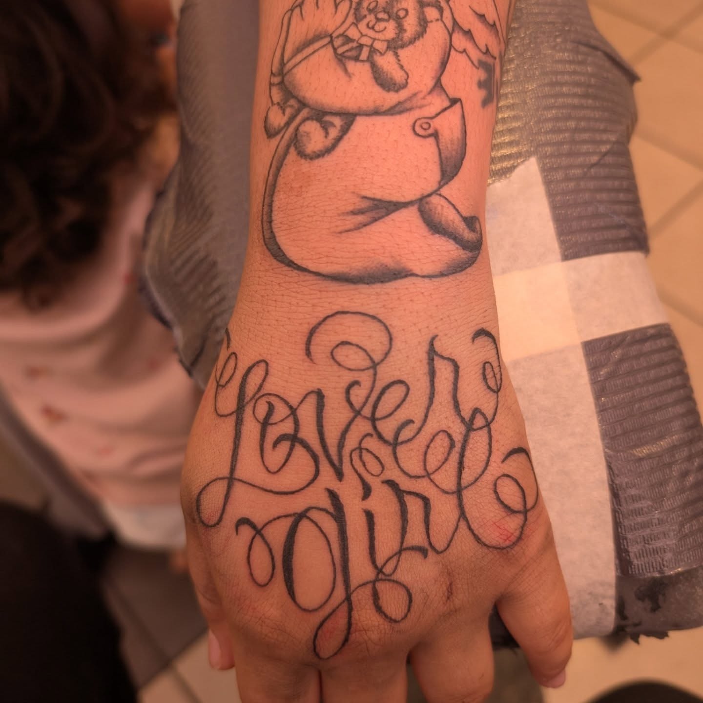 Love girl black and grey tattoo on the hand by Markus Hicks