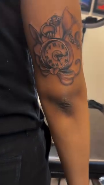 Pocket watch with floral elements lettering tattoo on the forearm by Lopez Dautruche