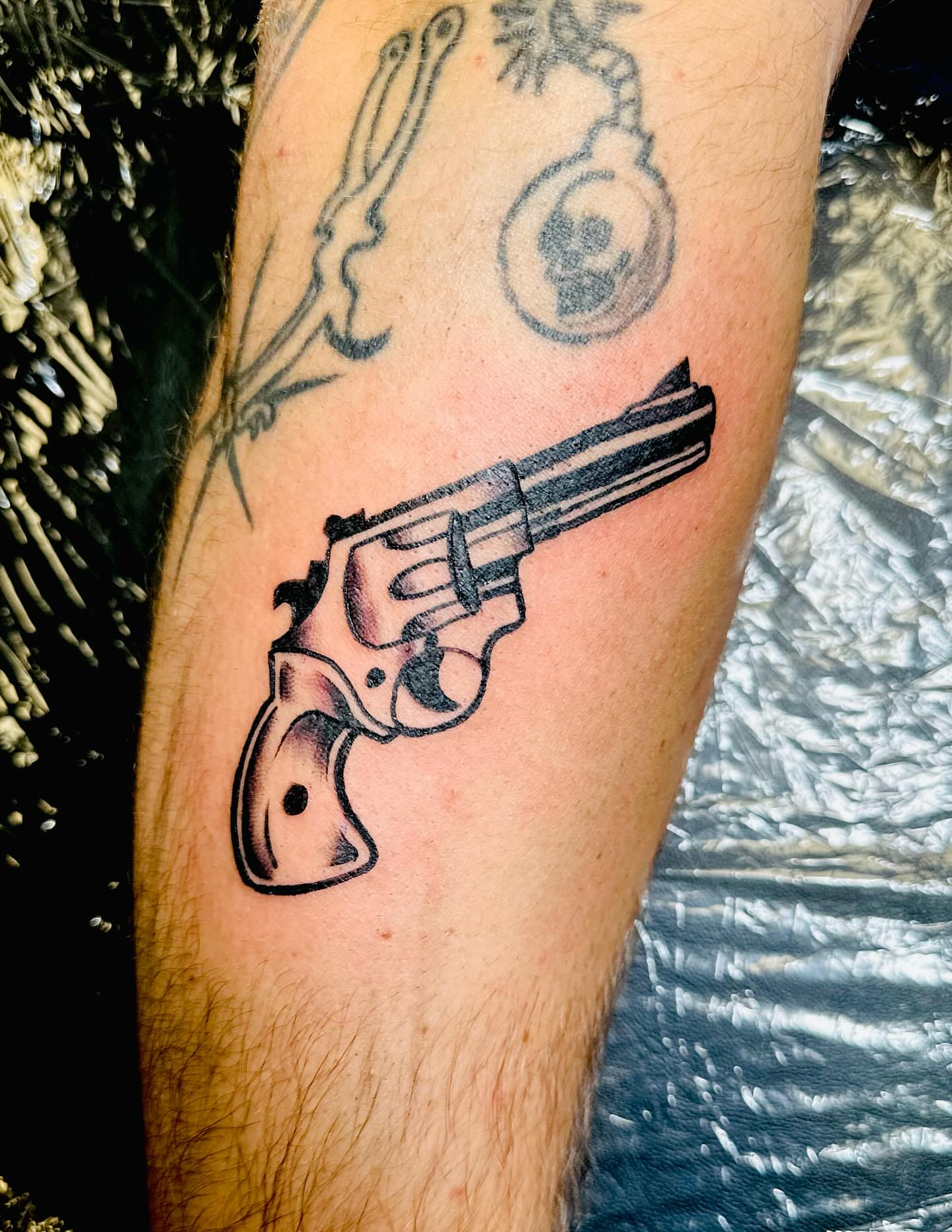 Revolver black and grey tattoo on the forearm by Ricky Flemate, San Antonio