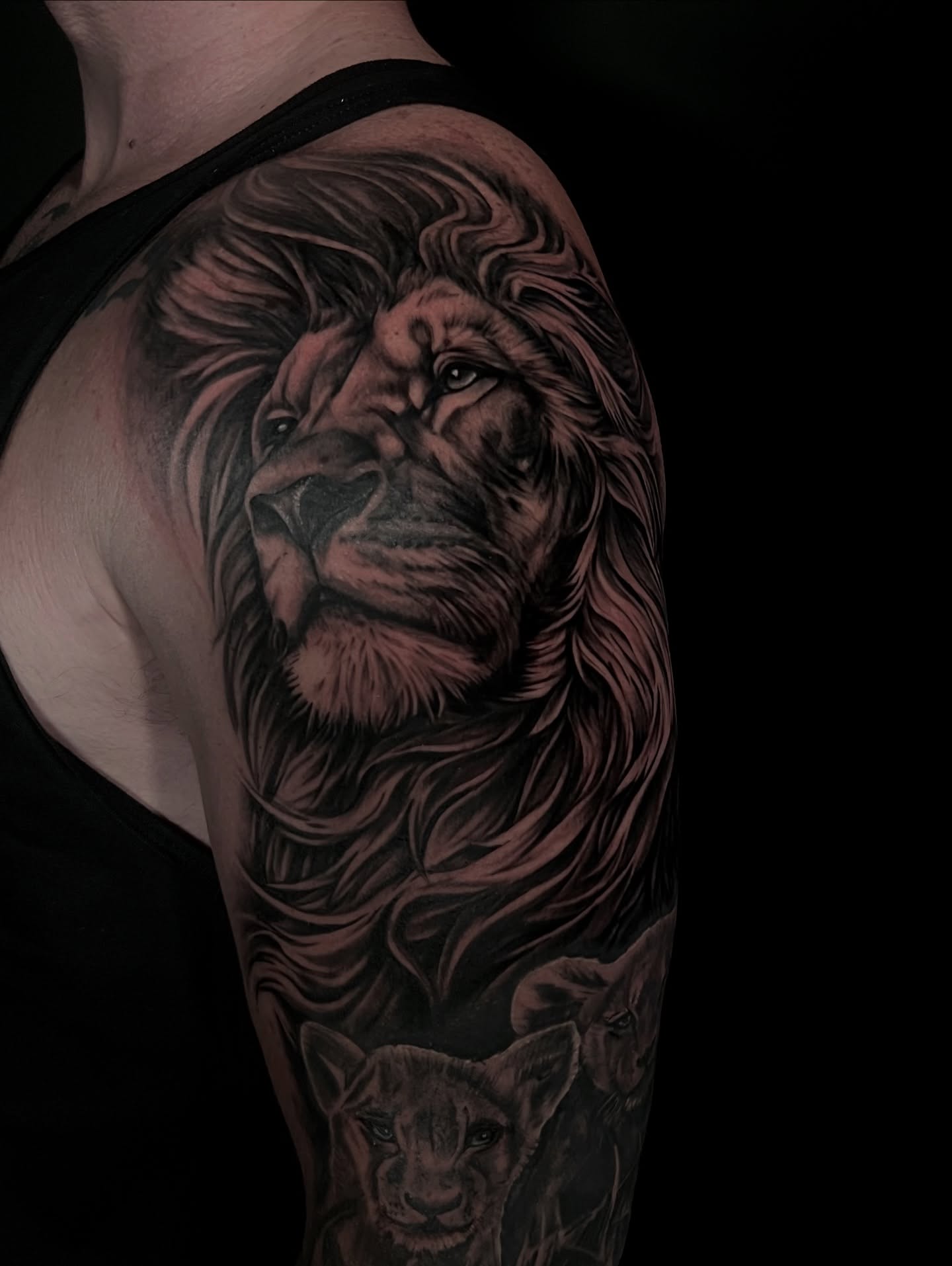 Lion realism tattoo on the upper arm by Chelsea Speirs