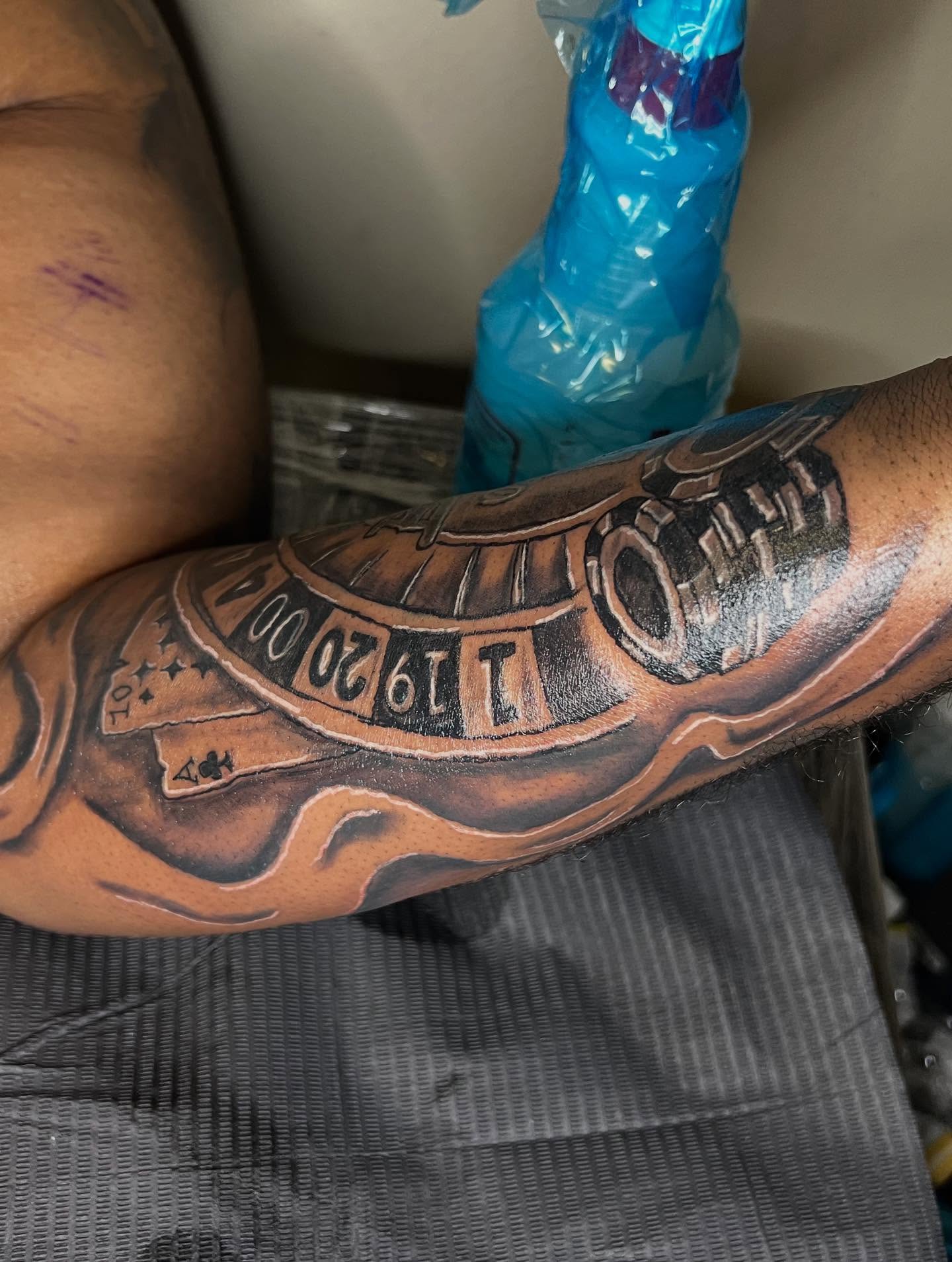 Roulette wheel black and grey tattoo on the forearm by Illuminink.gallery