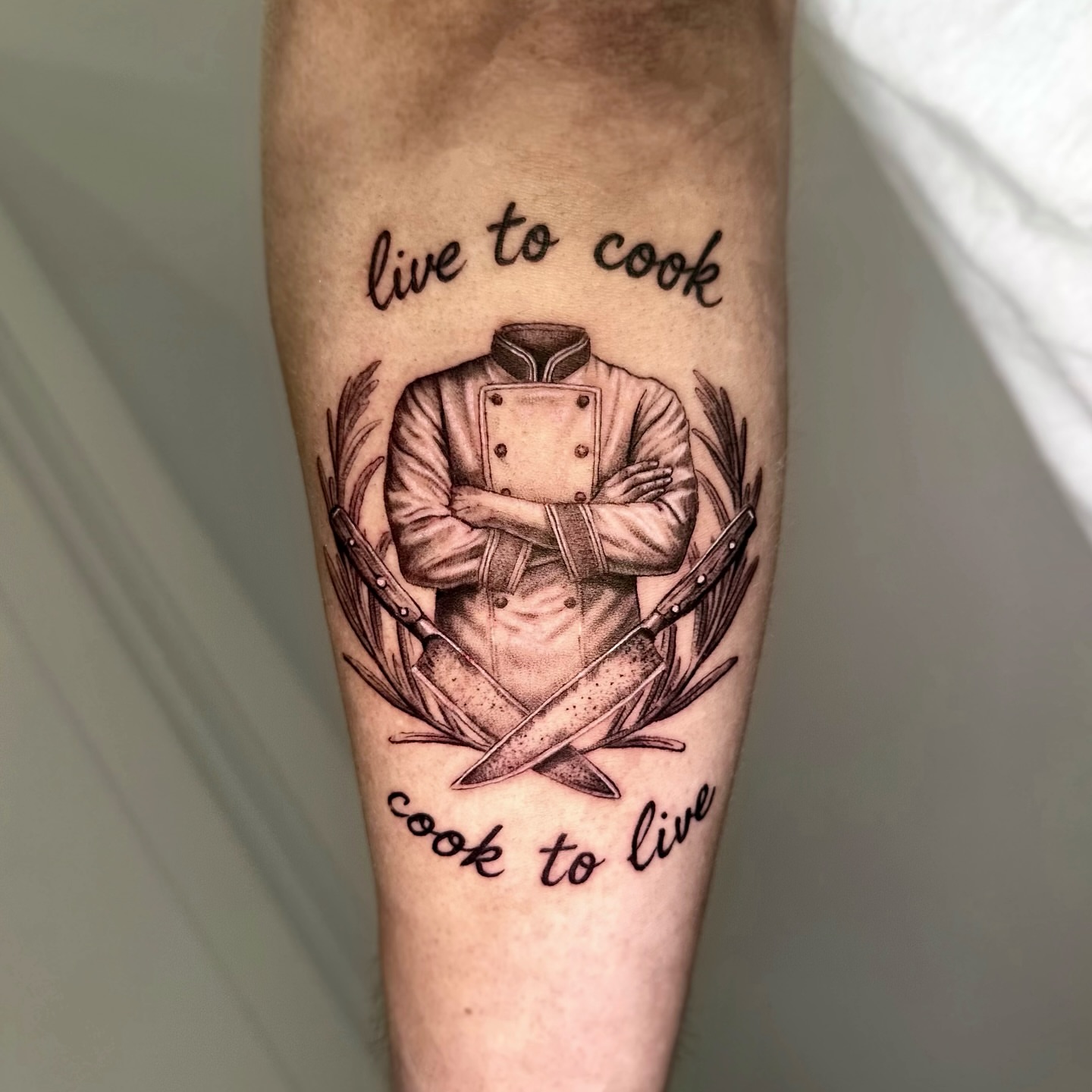 Chef with crossed arms black and grey tattoo on the forearm by Oxana