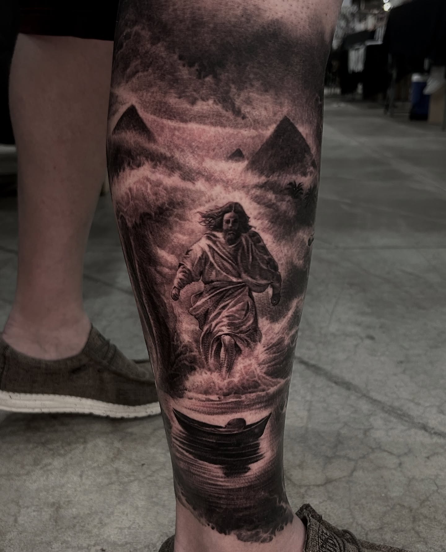 Jesus walking on water realism tattoo on the calf by Tyler Osburn