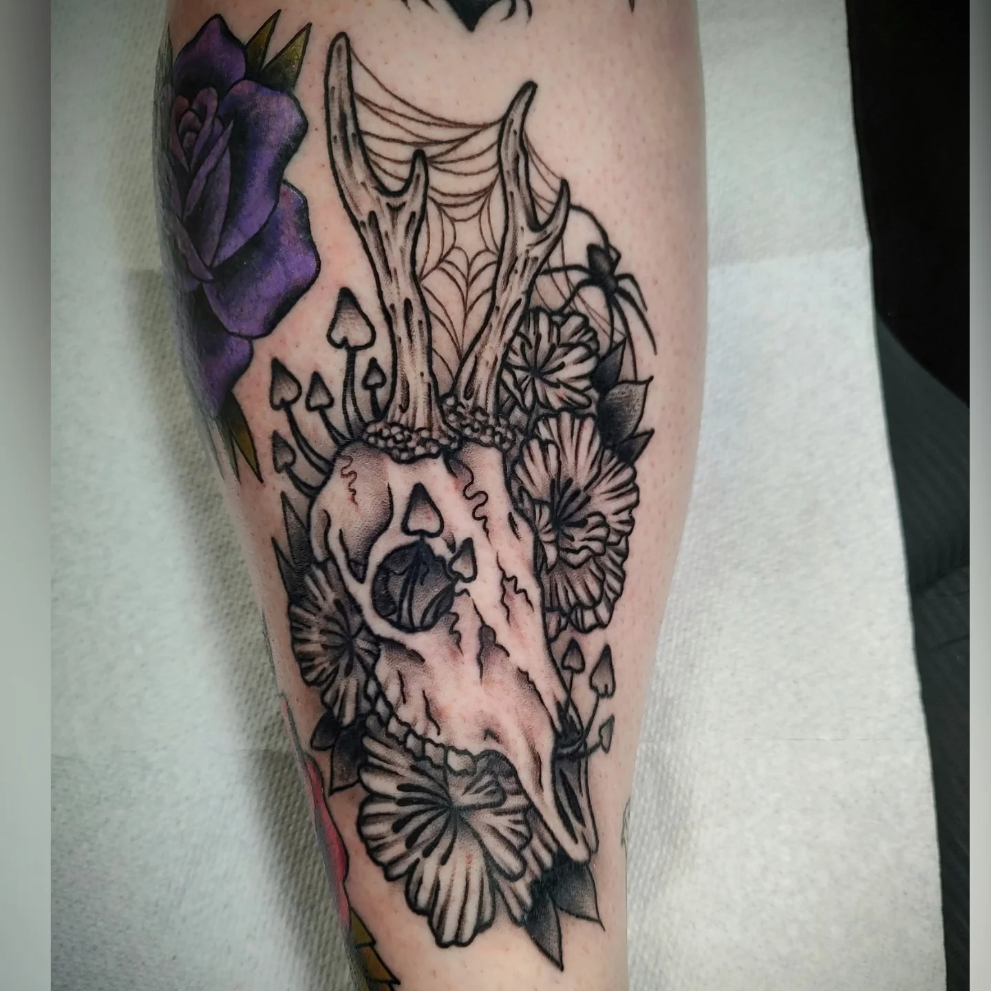 Deer skull with flowers realism tattoo on the forearm by Hope Higgins