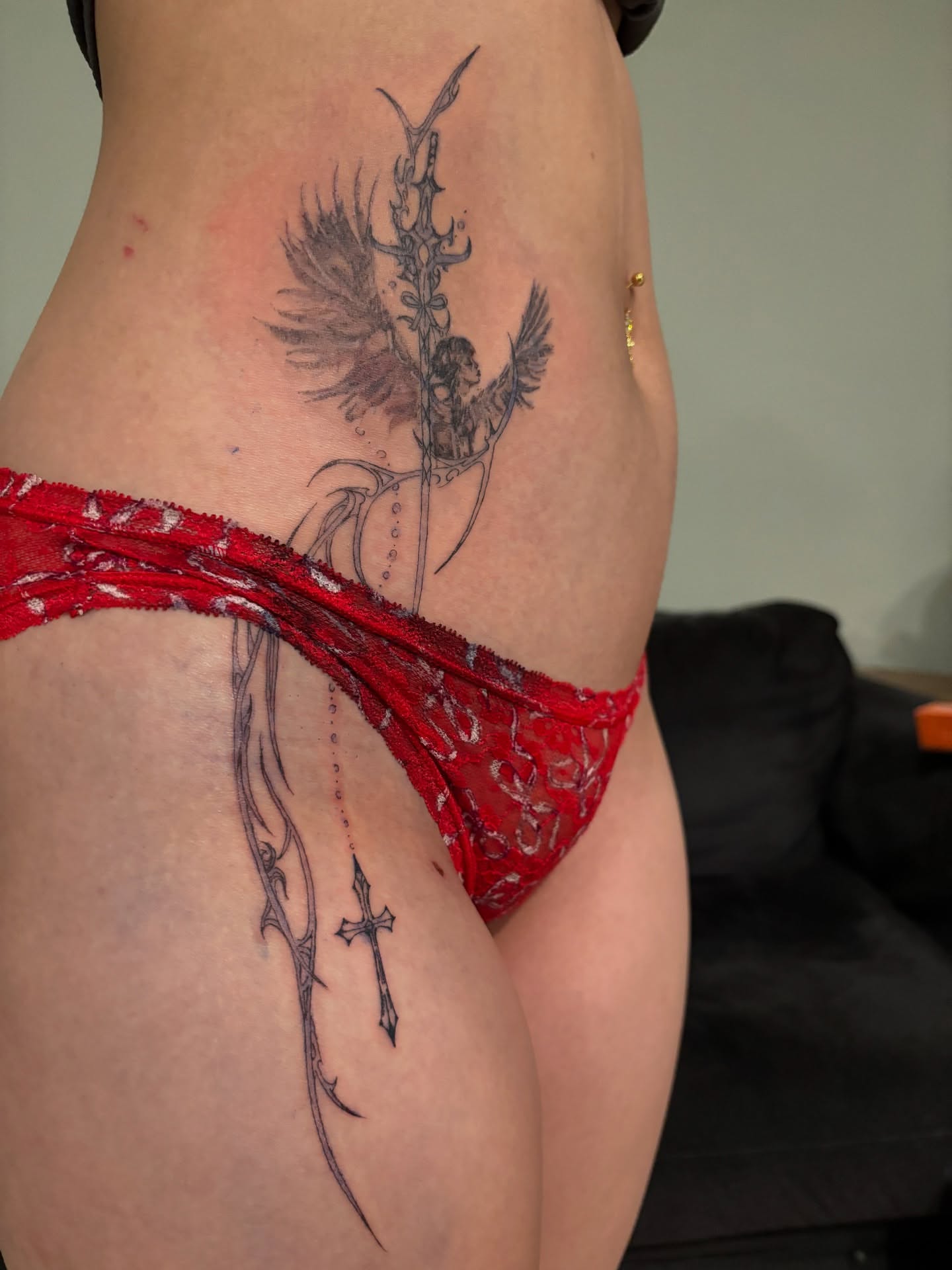 Angelic figure with cross black and grey tattoo on the thigh by @miffythereaper