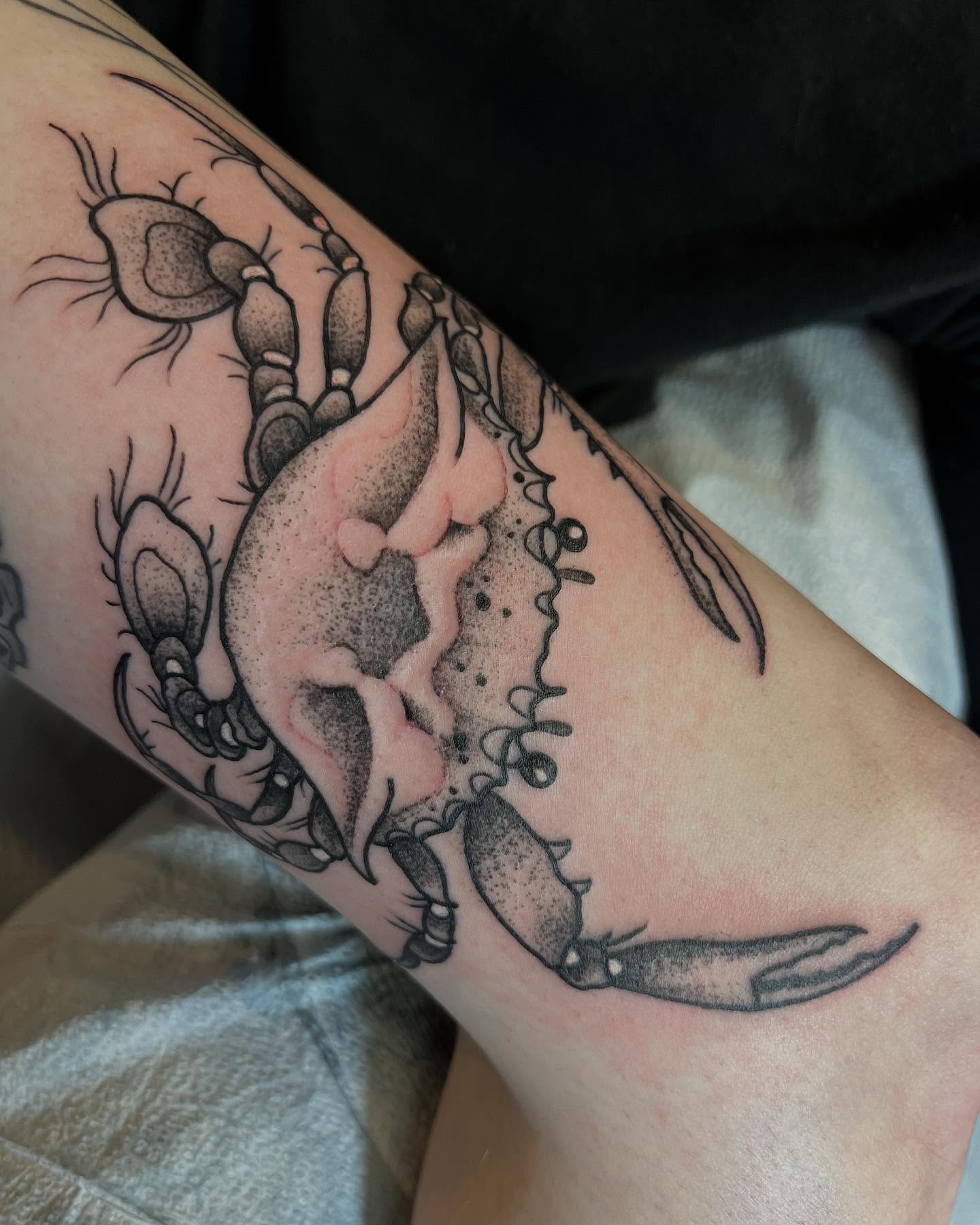 Crab dotwork tattoo on the forearm by Cody Marl