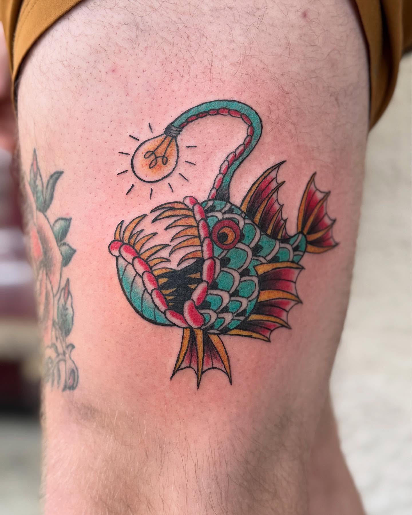 Fish with light bulb American traditional tattoo on the thigh by Marissa Losier