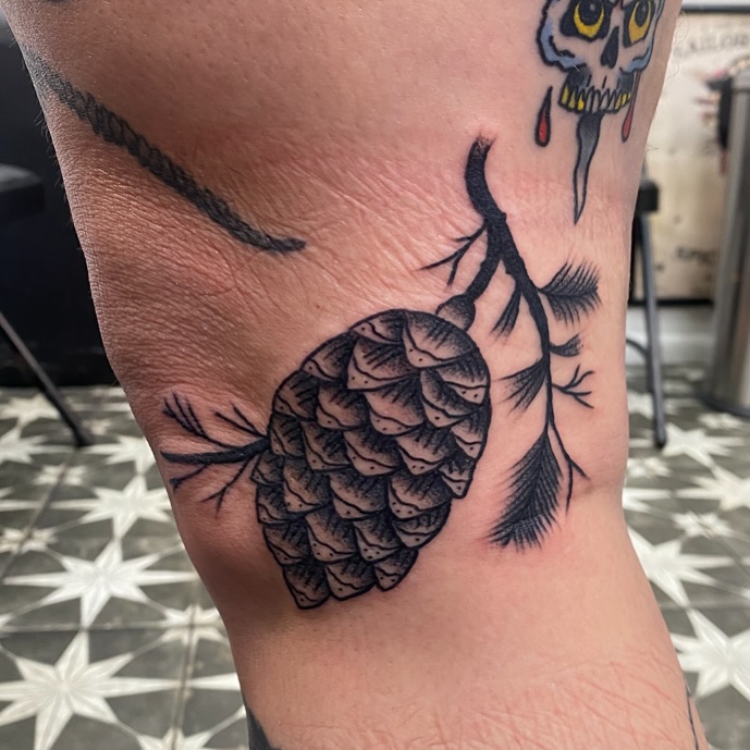 Pinecone black and grey tattoo on the thigh by Mike Tapia