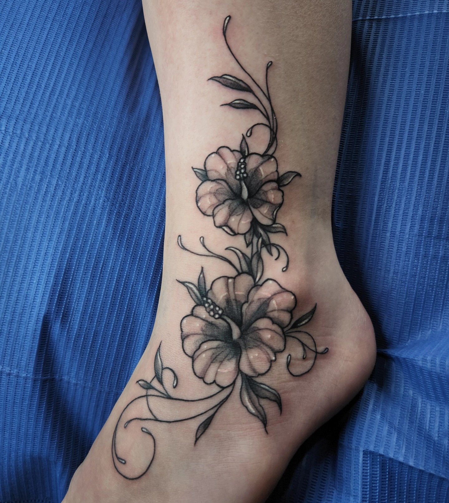 Floral design black and grey tattoo on the foot by Audrey Luther