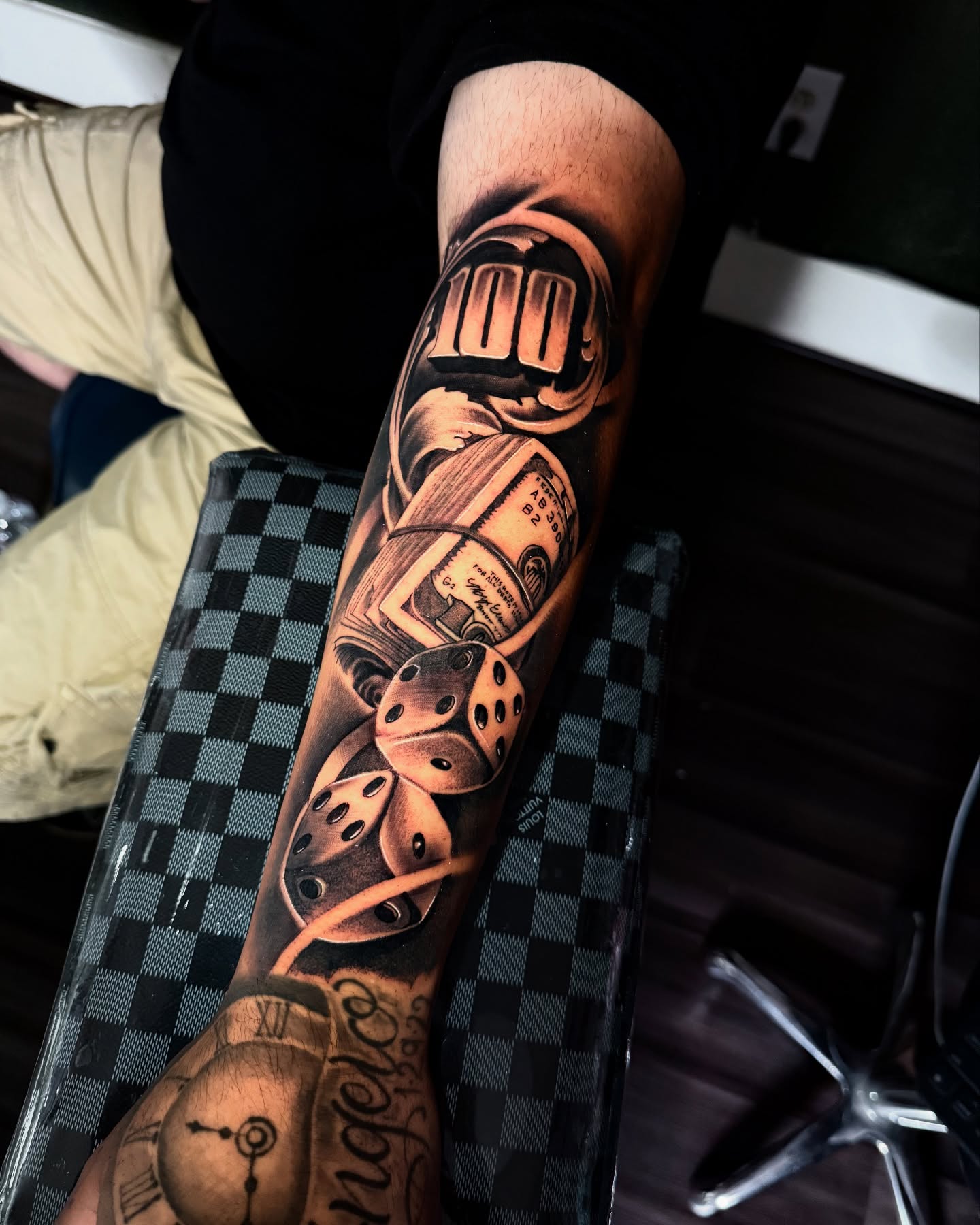 Dice and clock black and grey tattoo on the forearm by “Gonzo