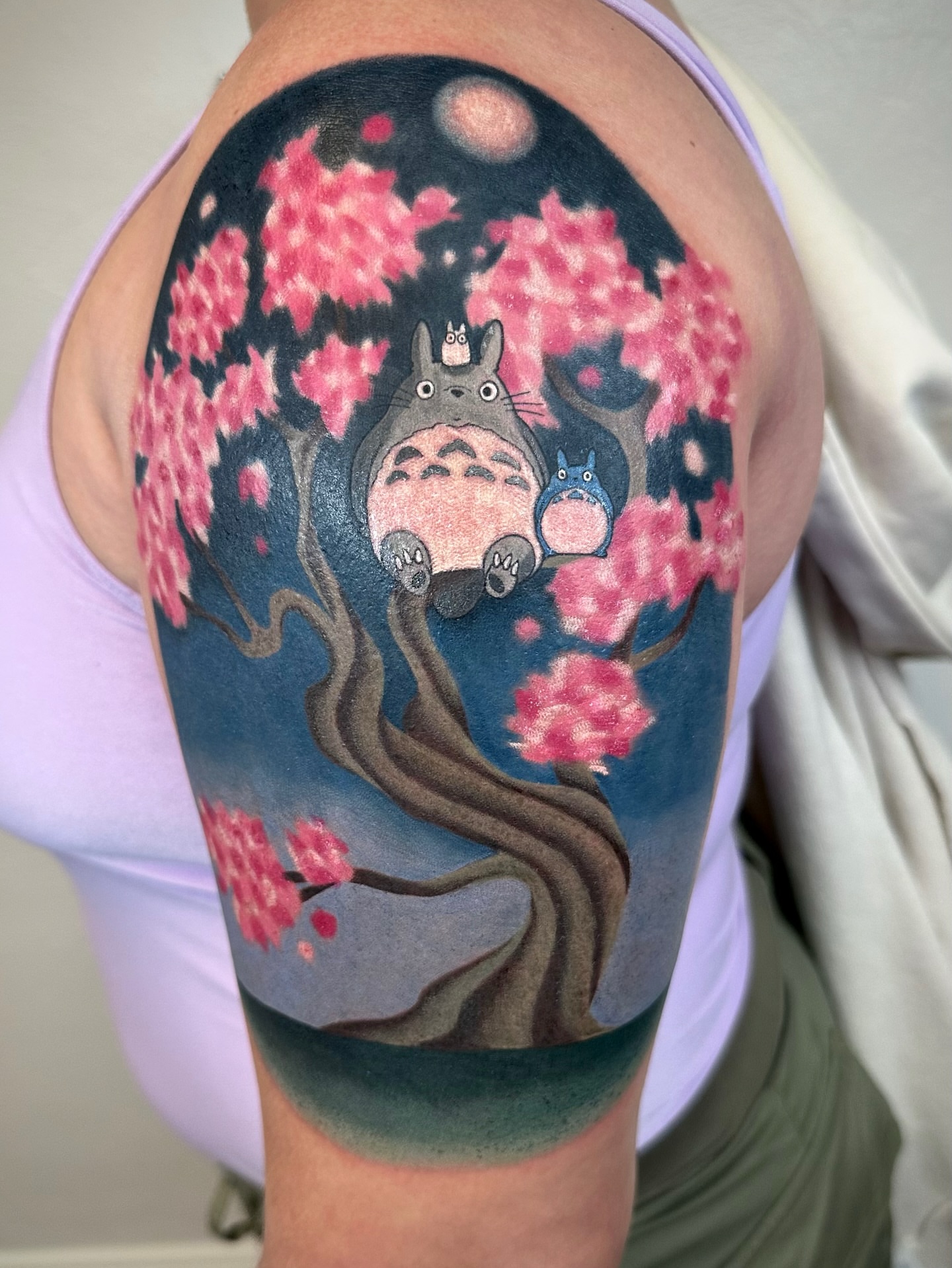 Cherry blossoms and Totoro dotwork tattoo on the shoulder by Savannah Compton