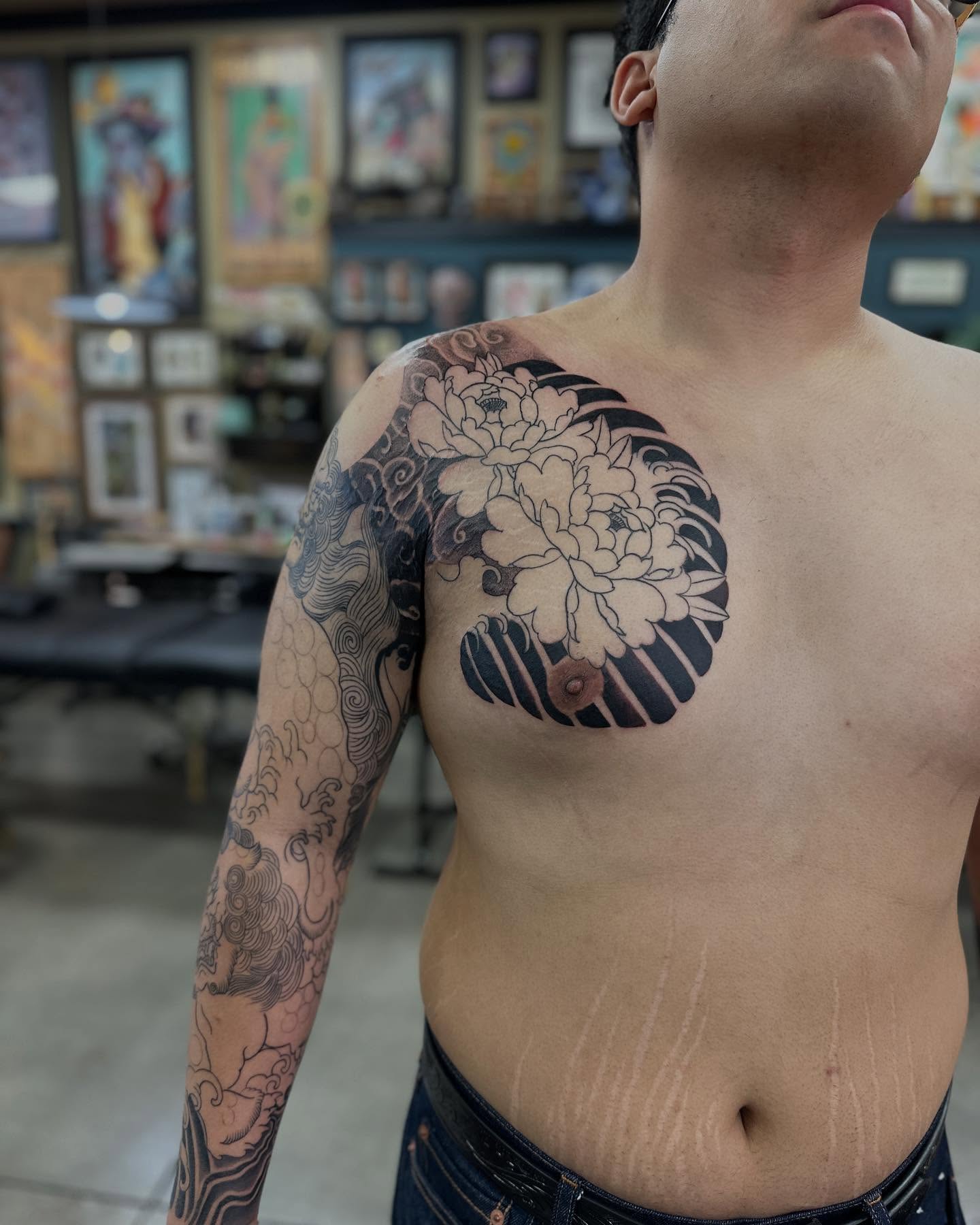 Floral design black and grey tattoo on the chest by Shawn Feng