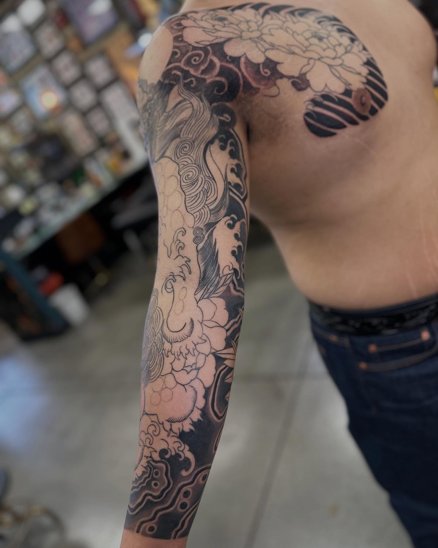 Peony and clouds japanese irezumi tattoo on the upper arm by Shawn Feng