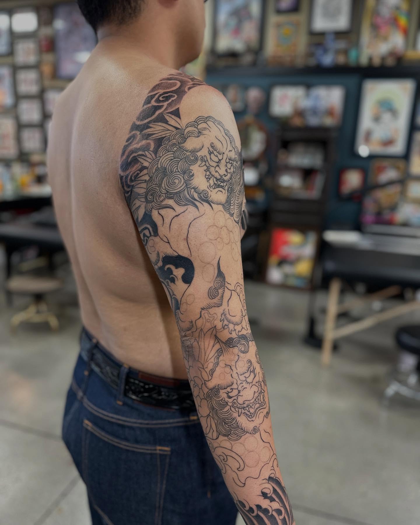 Lion and clouds japanese irezumi tattoo on the upper arm by Shawn Feng