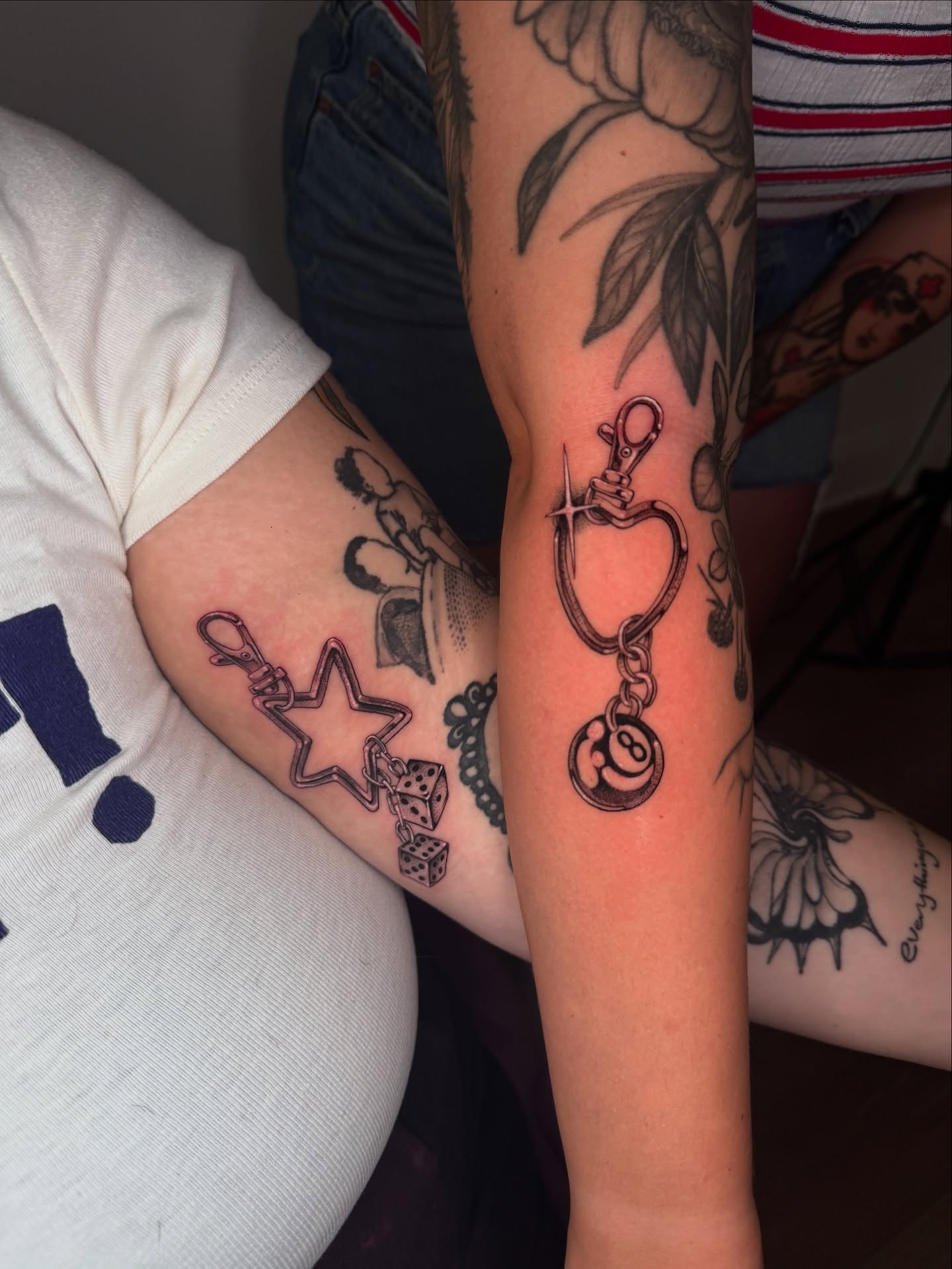 Handcuffs and keychain black and grey tattoo on the forearm by ella
