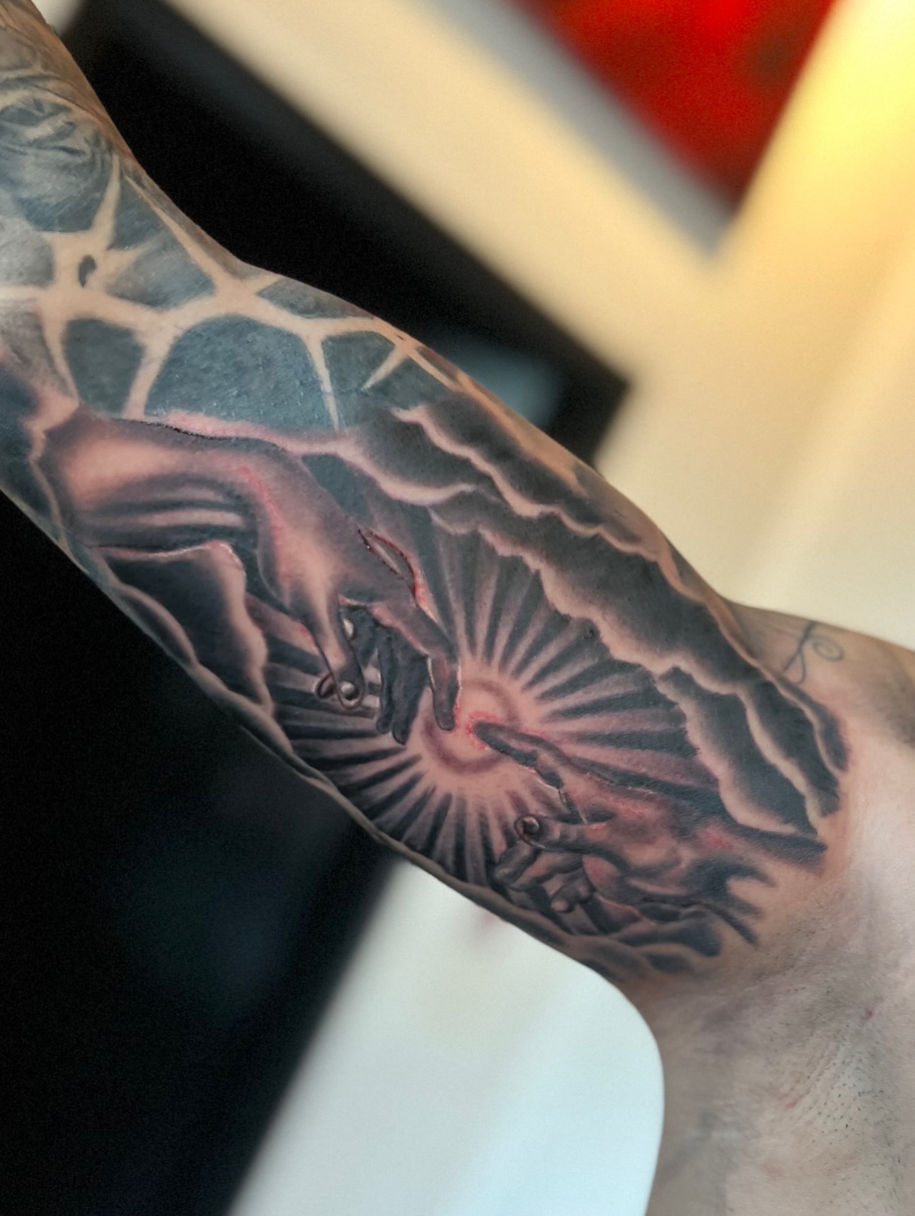 Hands reaching towards sun realism tattoo on the forearm by Sergio Ramirez