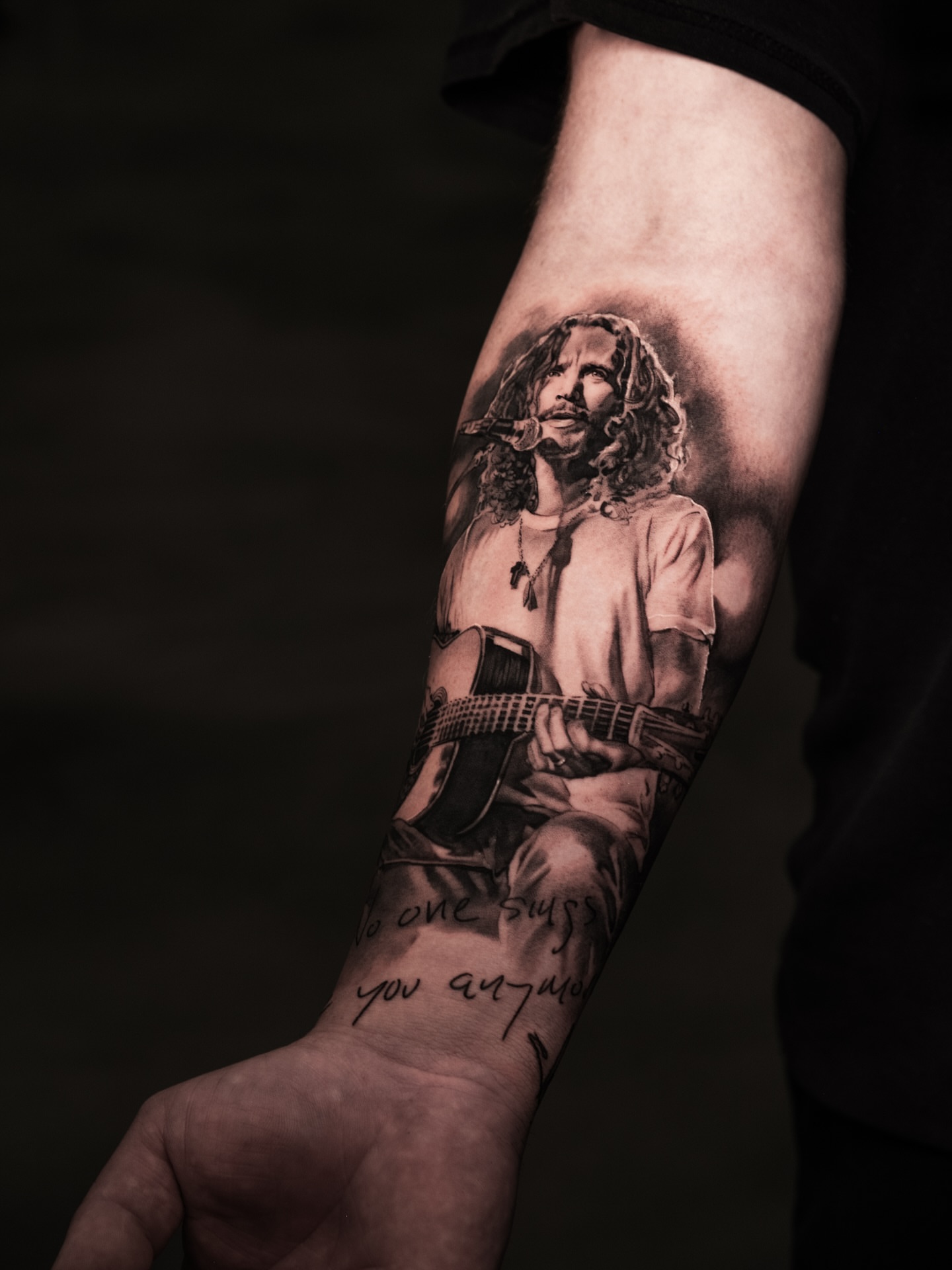 Singer with guitar realism tattoo on the forearm by Anastasia Ritova
