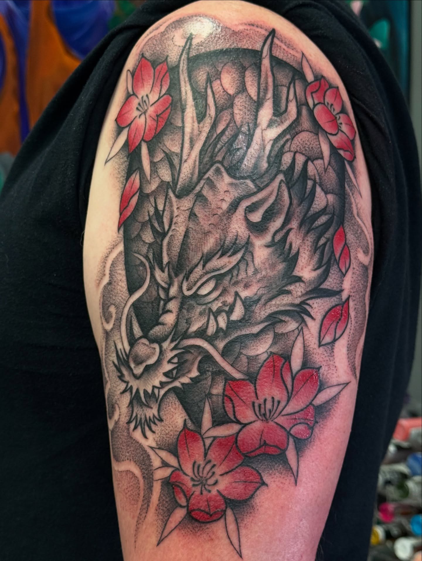 Dragon and flowers dotwork tattoo on the upper arm by jenna clark🎨